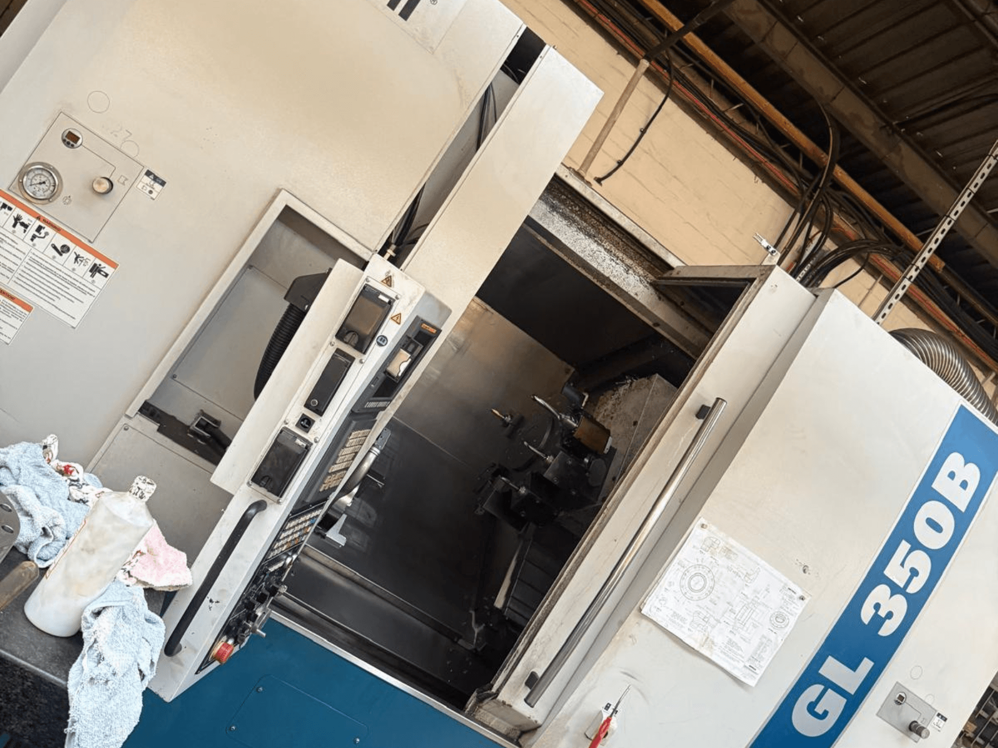 Horizontalios tekinimo staklės "Romi GL 350B", vaizdas iš priekio, valdymo skydelis ir atidarytos durys, pro kurias matomas vidus.