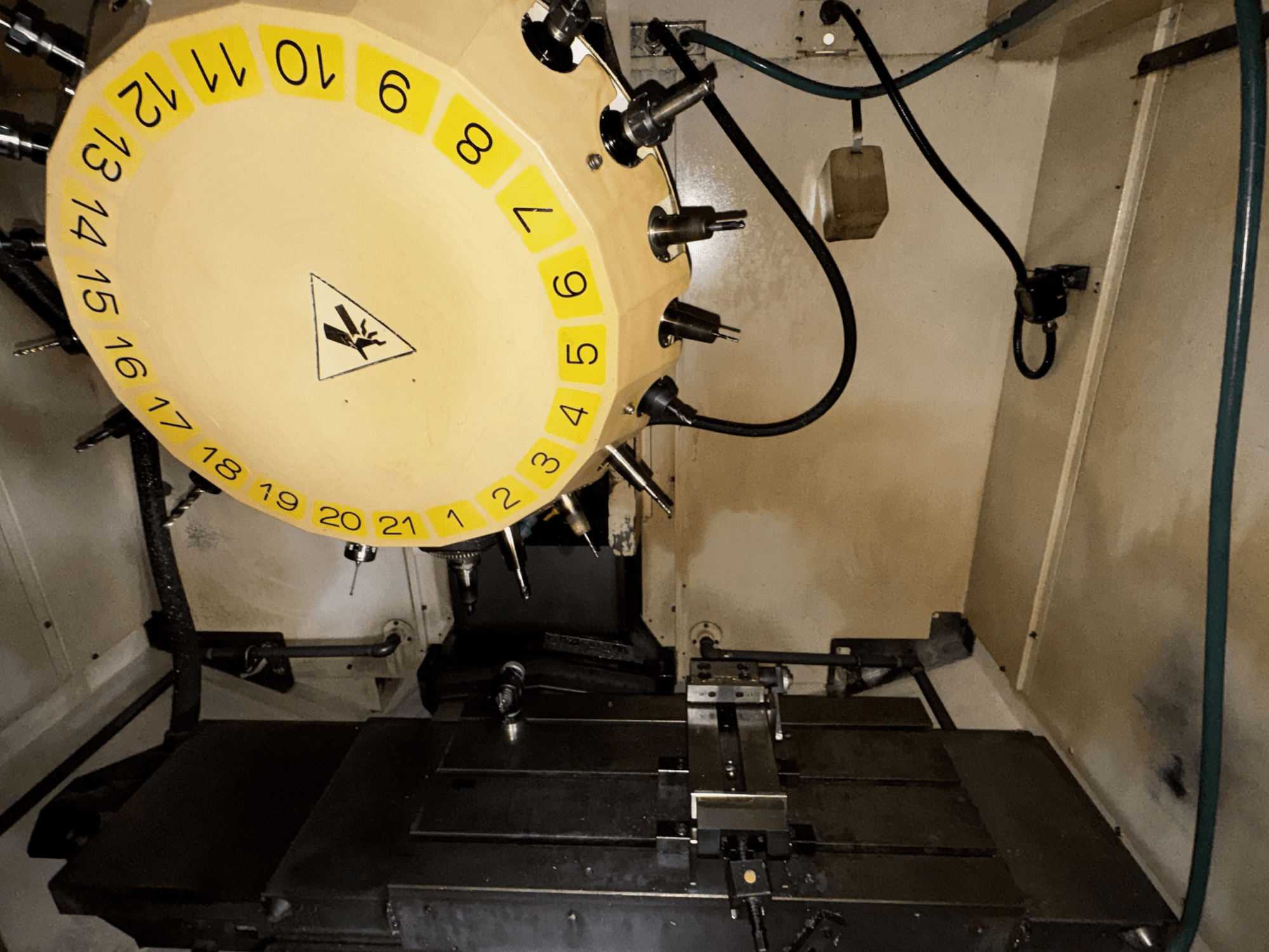 FANUC Robodrill alpha-T21iFL vertikalaus apdirbimo centro vidaus vaizdas, matomas įrankių karuselis ir apdirbimo stalas.