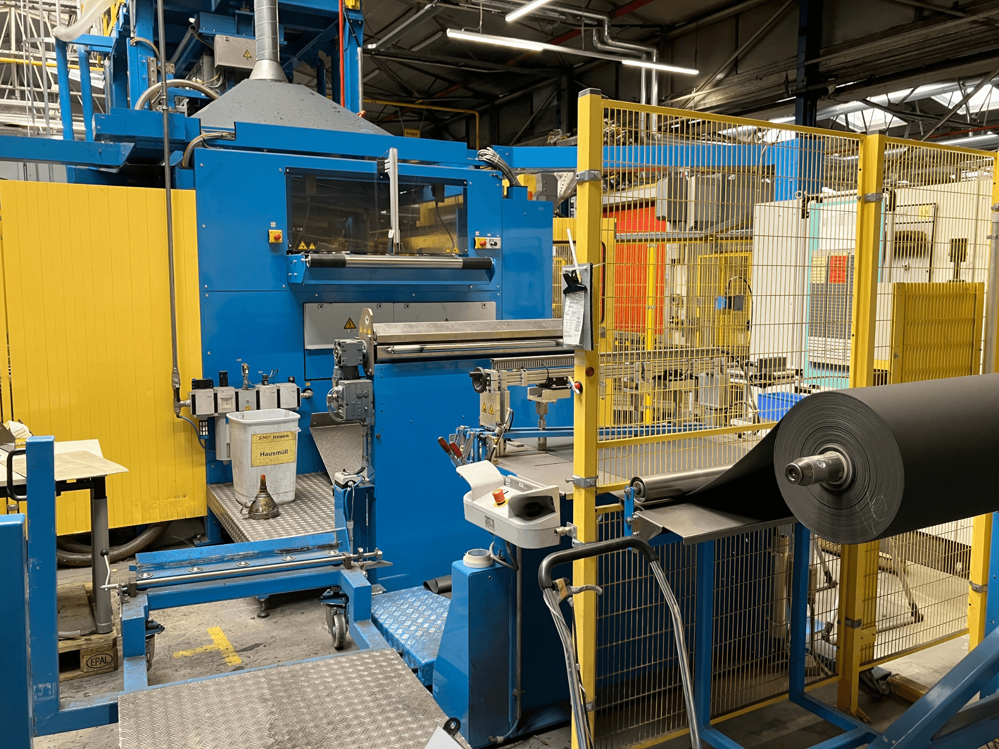 KIEFEL KLS 86/235 plastiko apdirbimo mašina iš priekio, su juodos medžiagos ritiniu ir valdymo pultu.