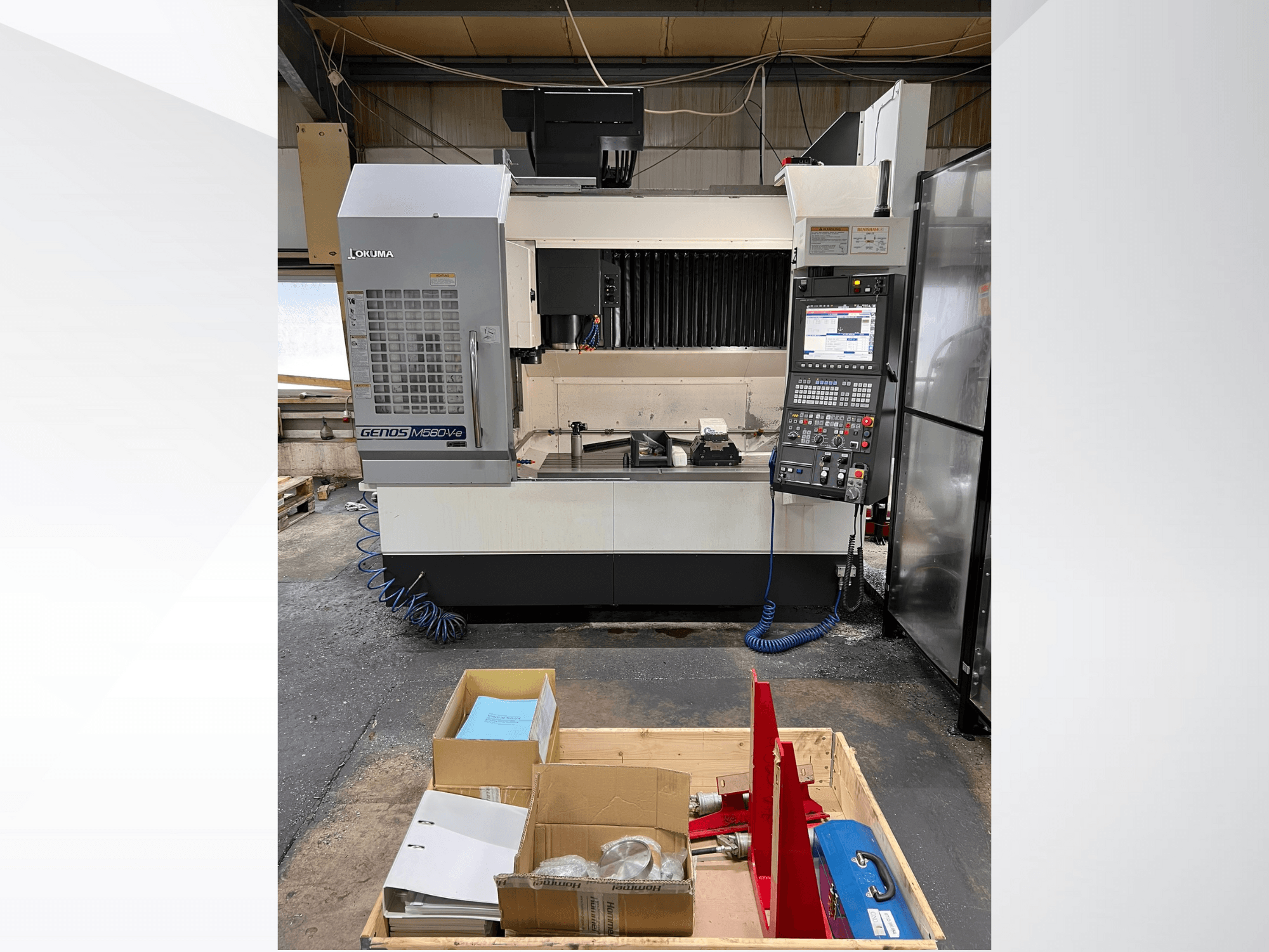 Vertikalaus apdirbimo centras "Okuma GENOS M460V-5", vaizdas iš priekio, matomas valdymo skydelis ir įrankiai ant darbastalio.