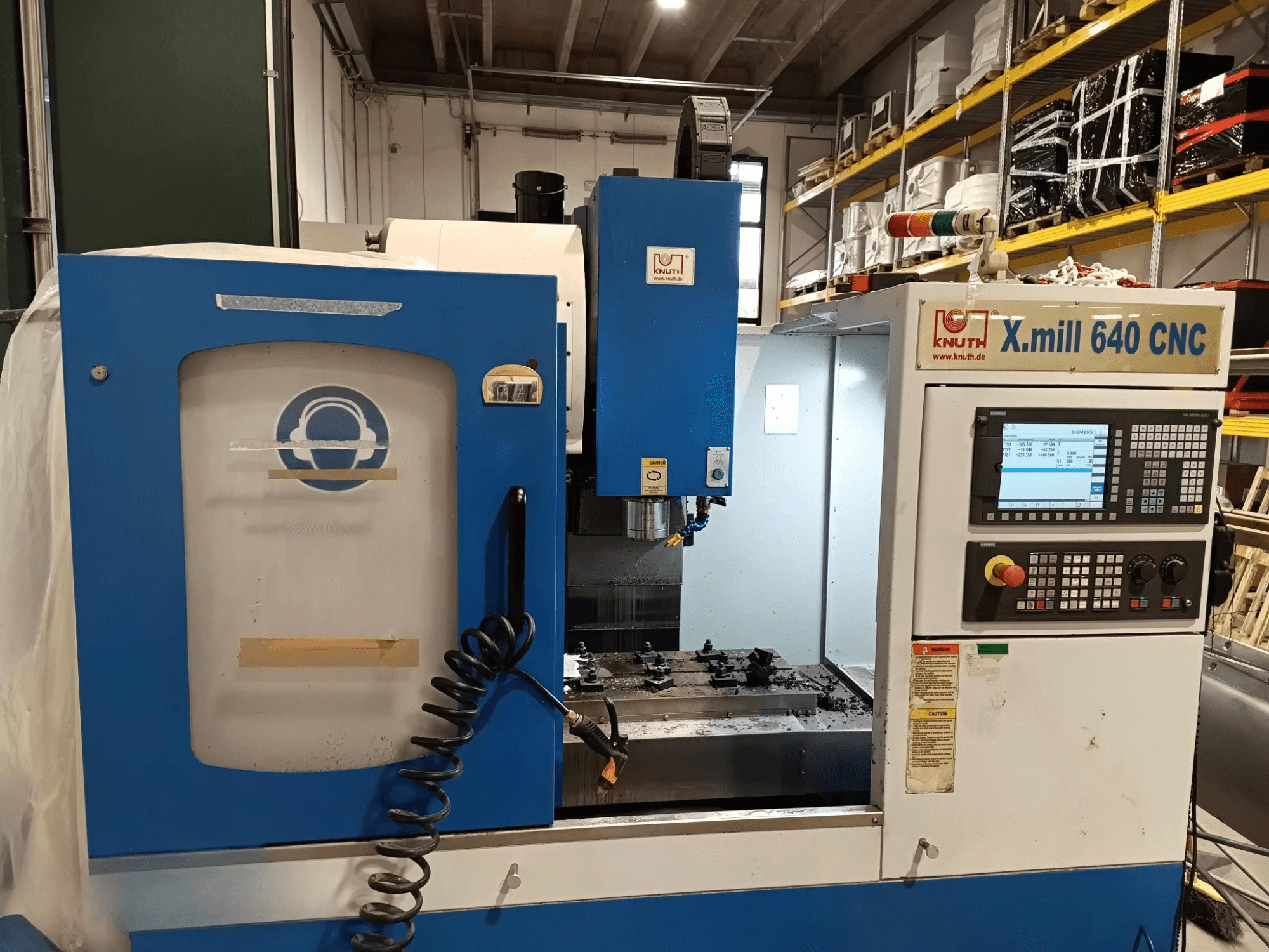 CNC staklės "Knuth X.mill 640" iš šono, su valdymo skydeliu, suklio sritimi ir matomu ruošinio nustatymu.