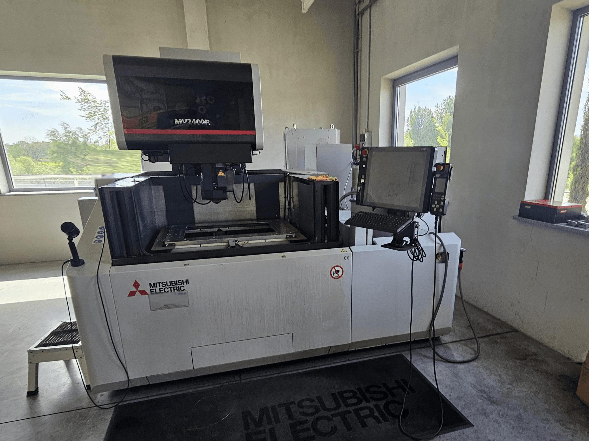 "Mitsubishi MV2400R" vielos elektroerozinio apdirbimo staklės dirbtuvėse su jutiklinio ekrano valdymo skydeliu ir darbo vieta.