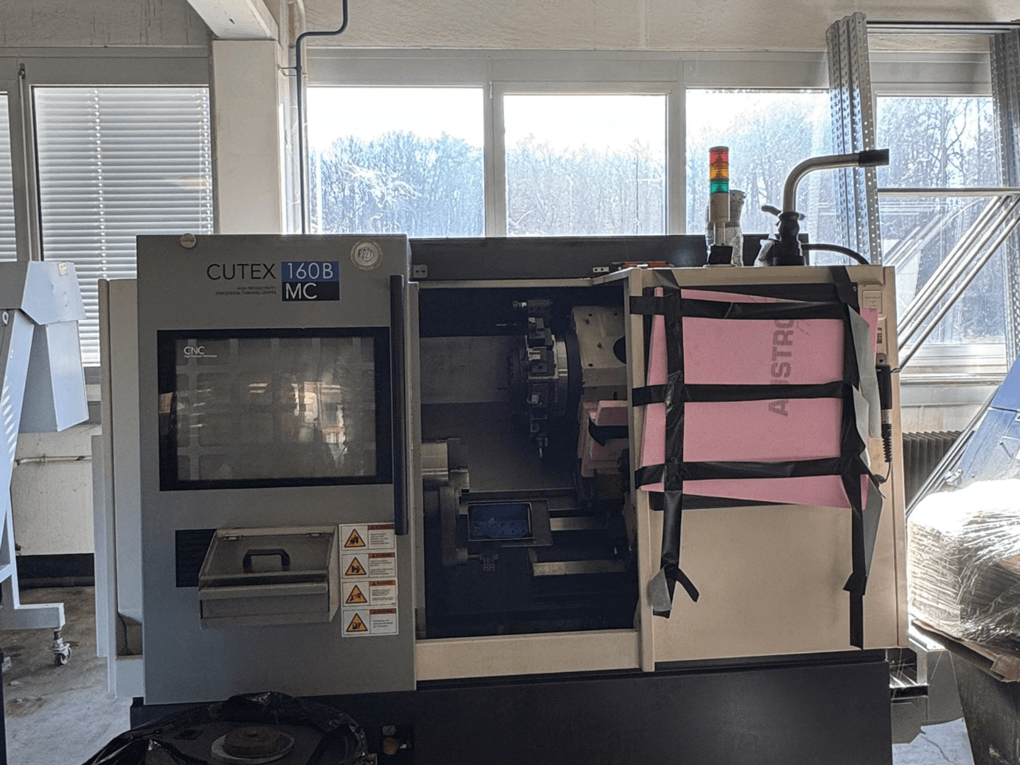 HWACHEON CUTEX 160 B VDI horizontalios tekinimo staklių vaizdas iš priekio su valdymo pultu ir aušinimo skysčio rezervuaru, su saugos lempute.