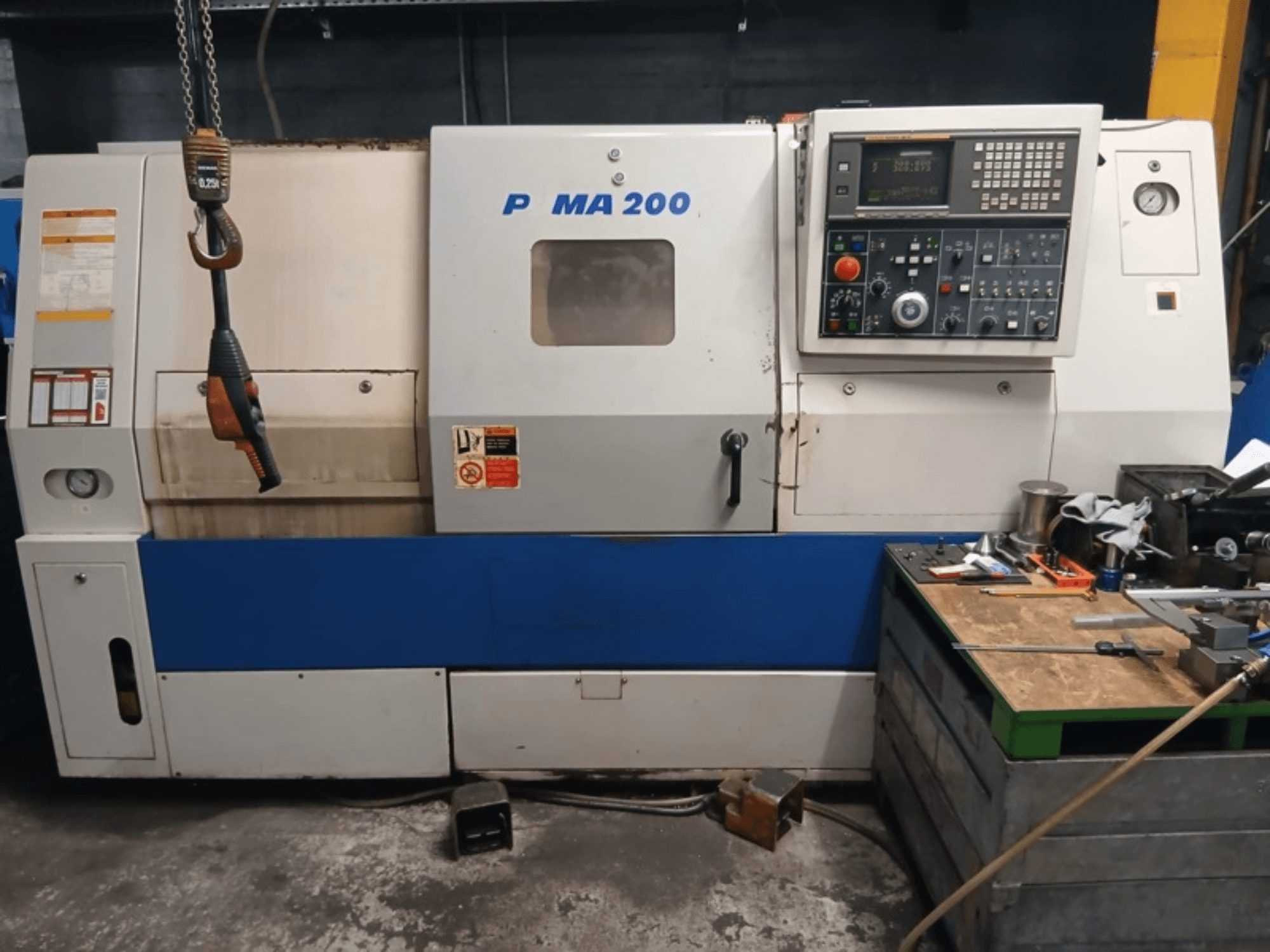 „DAEWOO EcoTurn 200“ horizontalios tekinimo staklių vaizdas iš priekio, kuriame matomas valdymo skydas ir saugos etiketės.