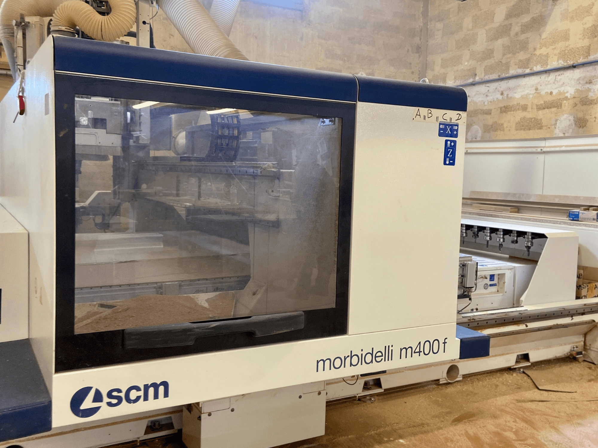 SCM Morbidelli M400F CNC staklės, vaizdas iš priekio, valdymo skydelis ir ant grindų matomos pjuvenos.