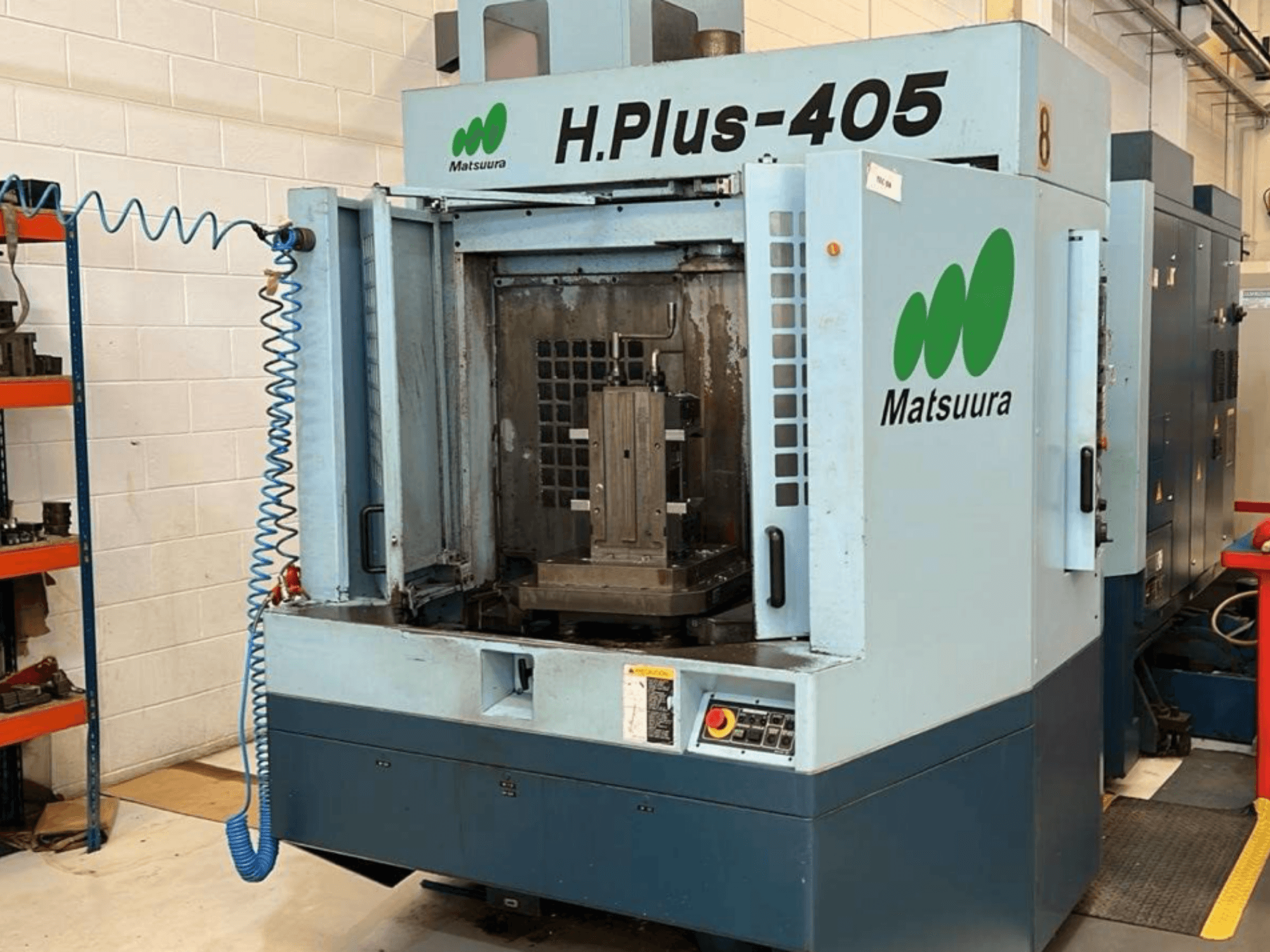 „Matsuura H.Plus 405“ horizontalaus apdirbimo centro vaizdas iš priekio su atidarytomis durelėmis, kuriame matoma darbo erdvė ir valdymo pultas.