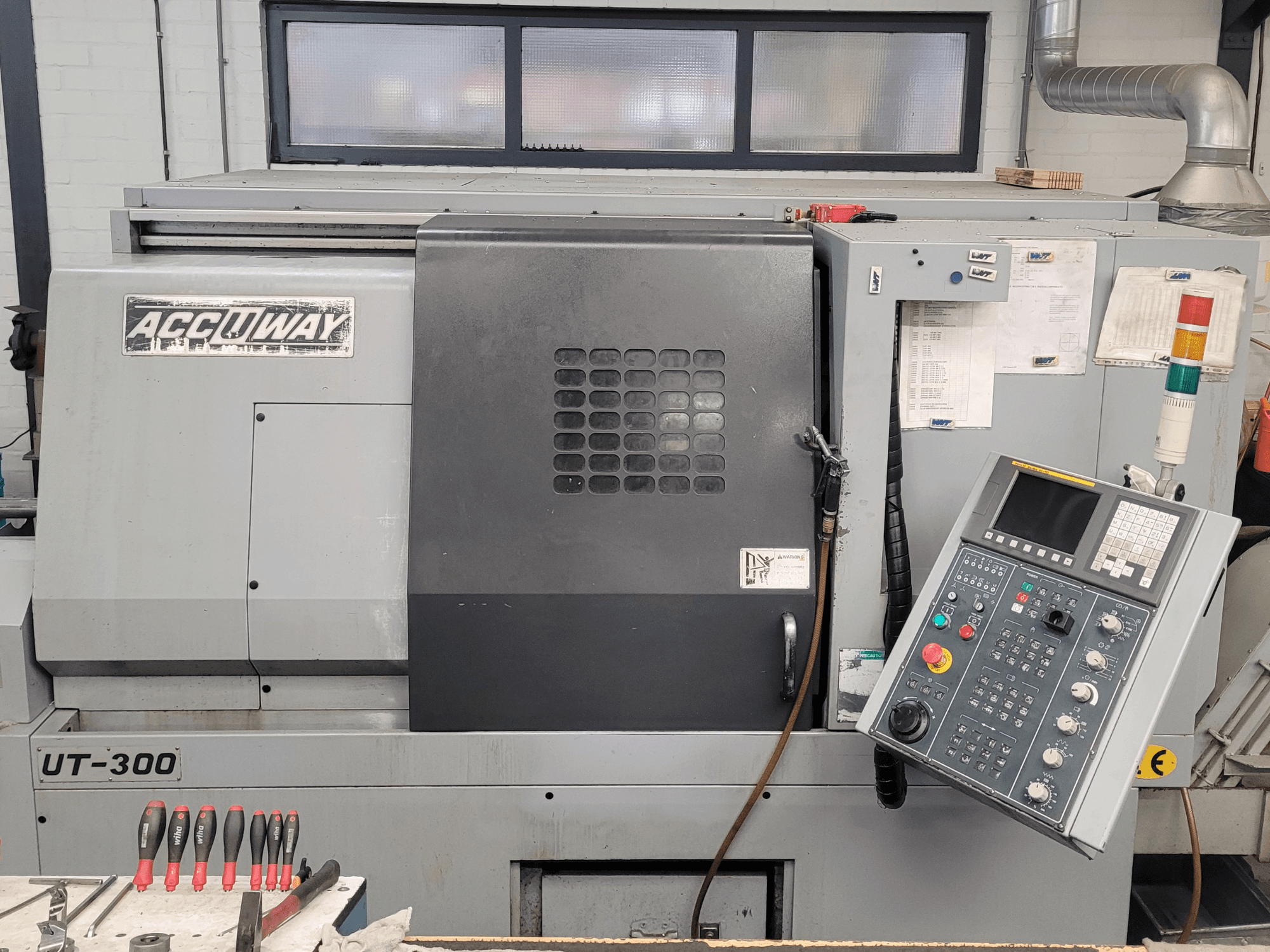 Accuway UT-300 CNC staklės iš priekio, su valdymo skydeliu ir įvairiais valdymo mygtukais, dirbtuvėse.