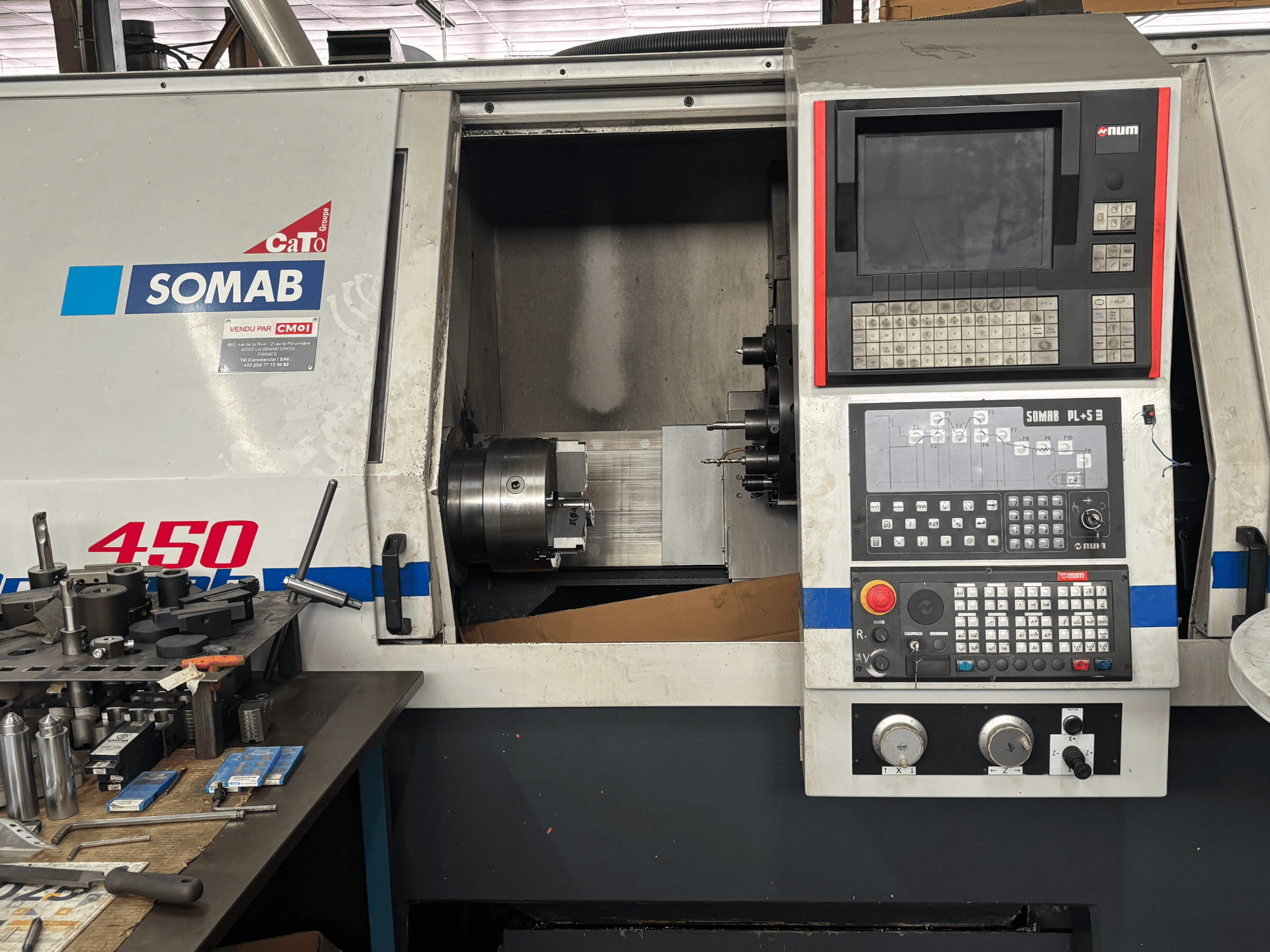 Baltoji SOMAB OPTIMA 450 horizontalios tekinimo staklių priekinis vaizdas, kuriame matomas skaitmeninis valdymo pultas ir pritvirtintas apdirbamas ruošinys.