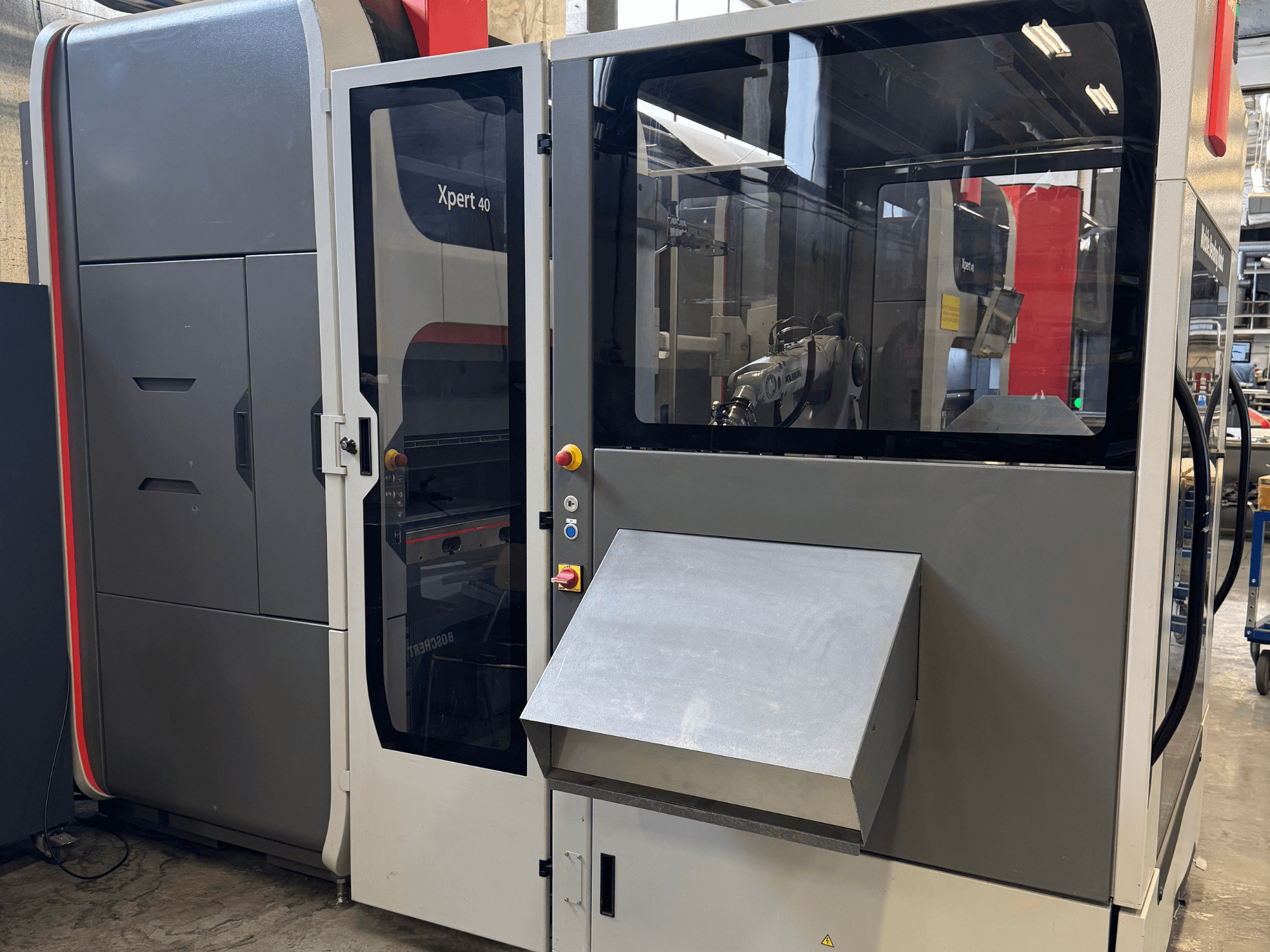 "Bystronic Xpert 40/1030" presas iš priekio, kuriame matyti valdymo skydelis, stiklinis korpusas ir švaraus dizaino savybės.