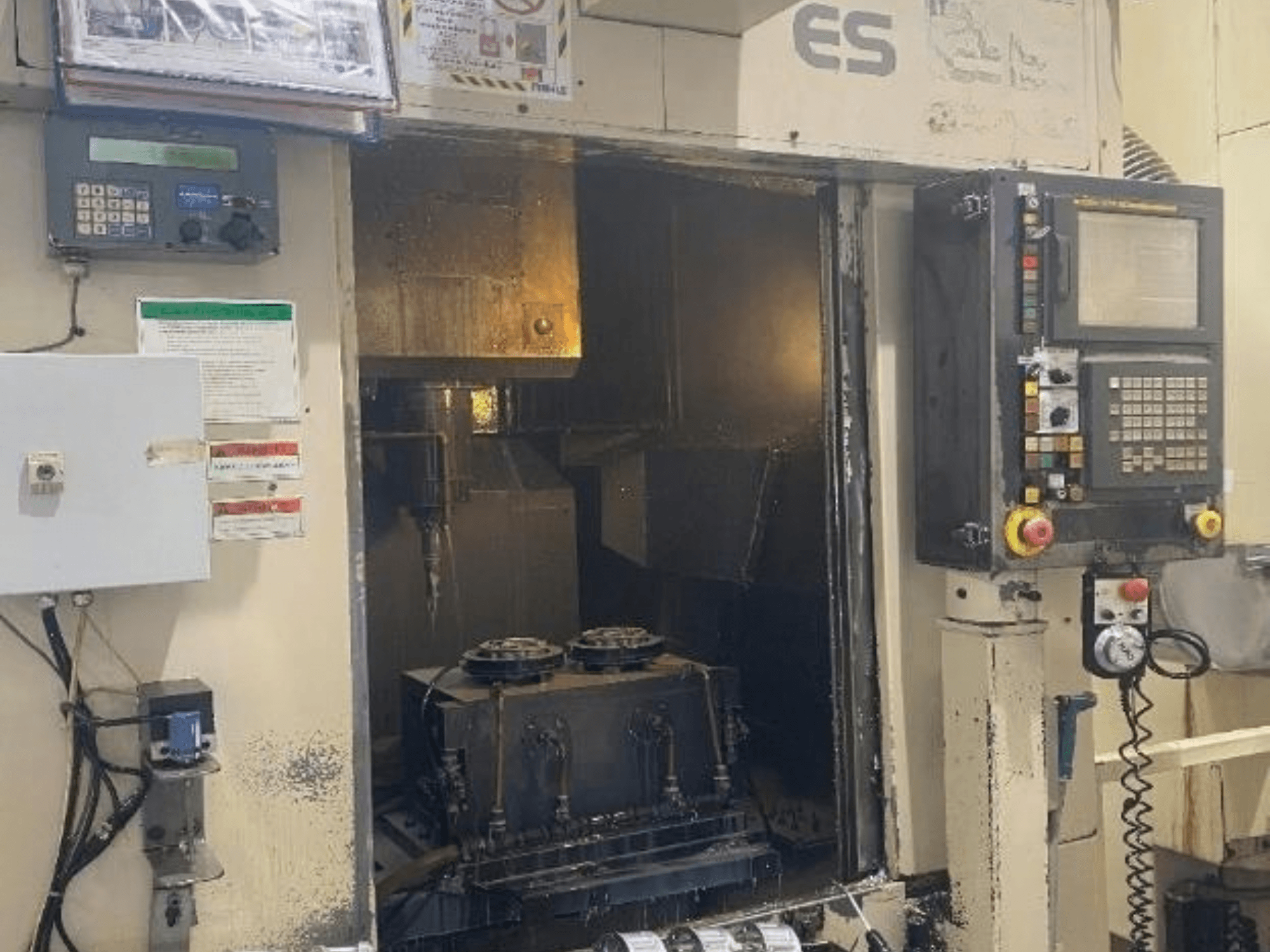 „Enshu ES450“ vertikaliojo apdirbimo centro vaizdas iš priekio, kuriame matomi valdymo elementai, vidus ir įrankių laikymo zona.