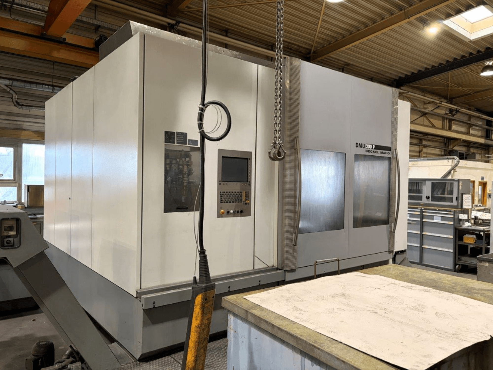 DMG MORI DMU 200 universalus apdirbimo centras dirbtuvėse, vaizdas iš priekio, kuriame matomas valdymo skydelis ir išorinės savybės.