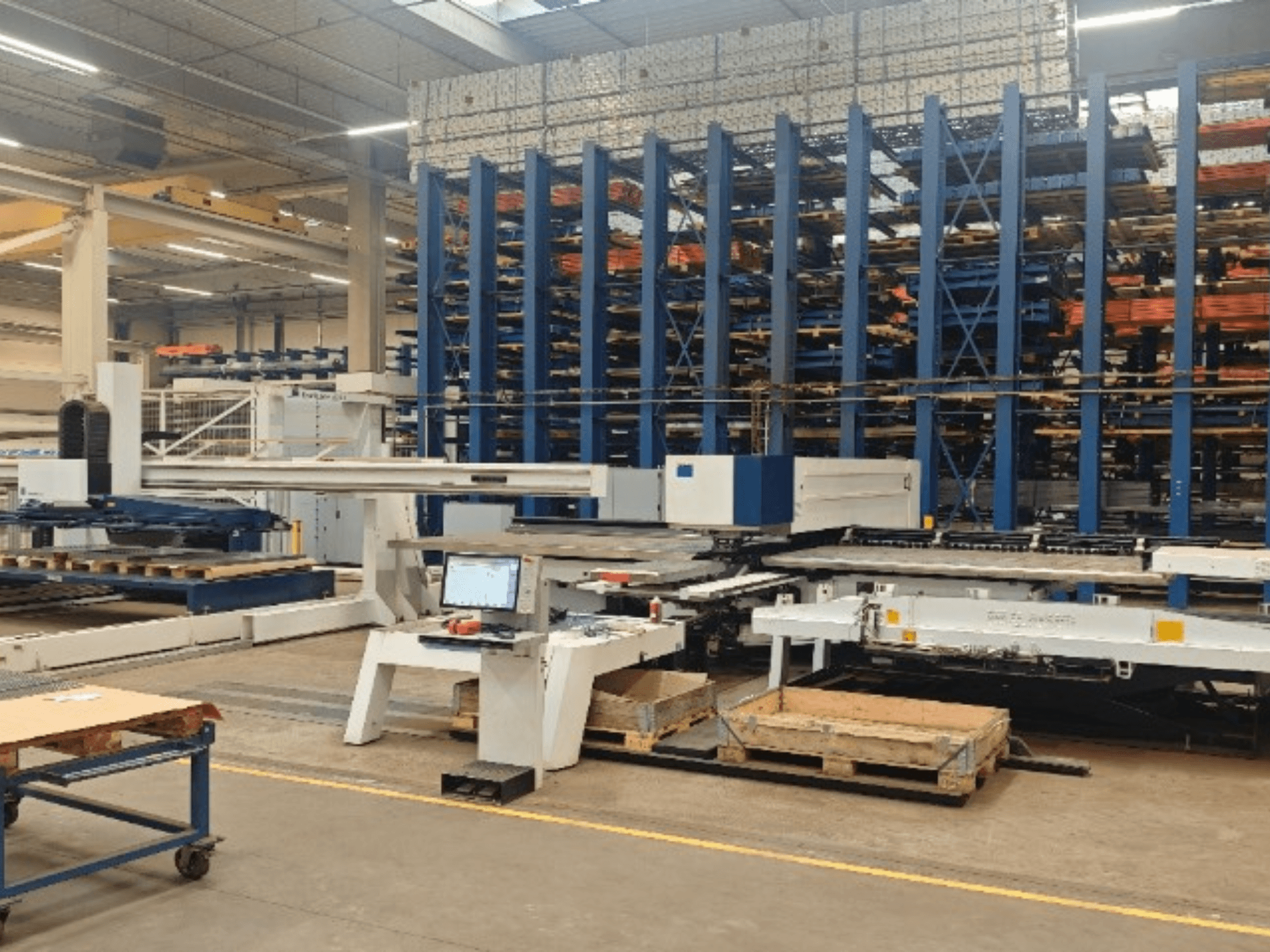 CNC štampavimo staklės „TRUMPF TruPunch 5000 S12“ dirbtuvėse, vaizdas iš priekio su valdymo pultu ir sandėliavimo zona.