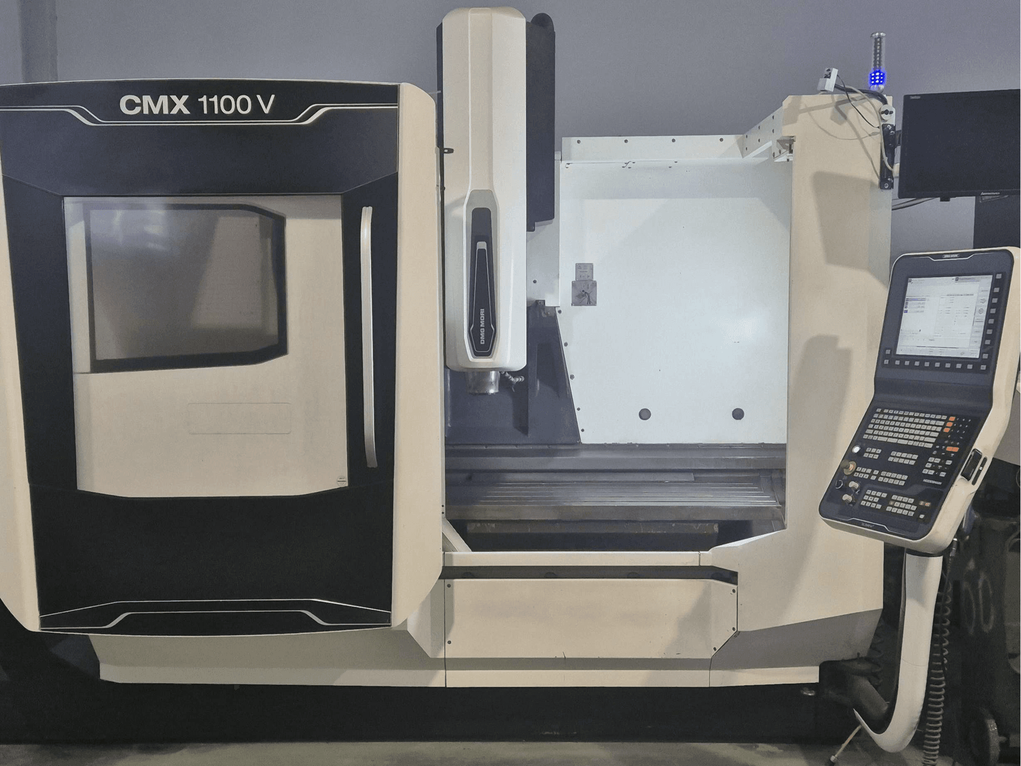 Vertikalusis apdirbimo centras „DMG MORI CMX 1100 V“, vaizdas iš priekio, kuriame matomas valdymo pultas ir staklių lovis.