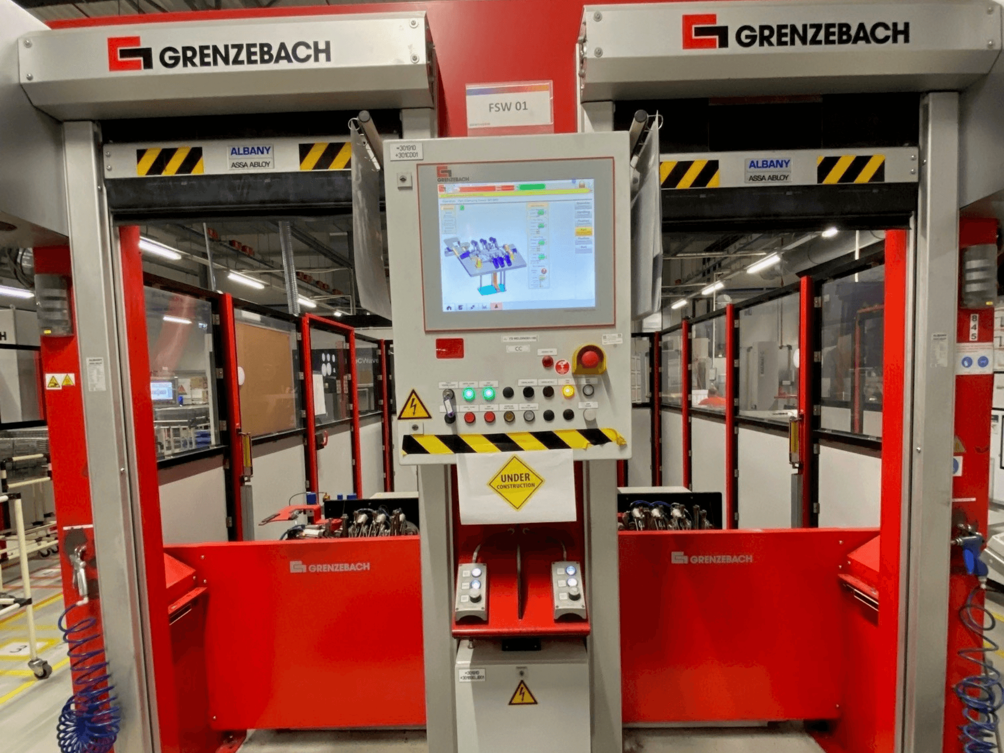 GRENZEBACH FSW GenRob 01 robotinės rankos vaizdas iš priekio, kuriame matomas valdymo skydelis su jutikliniu ekranu ir įvairiais valdymo mygtukais.