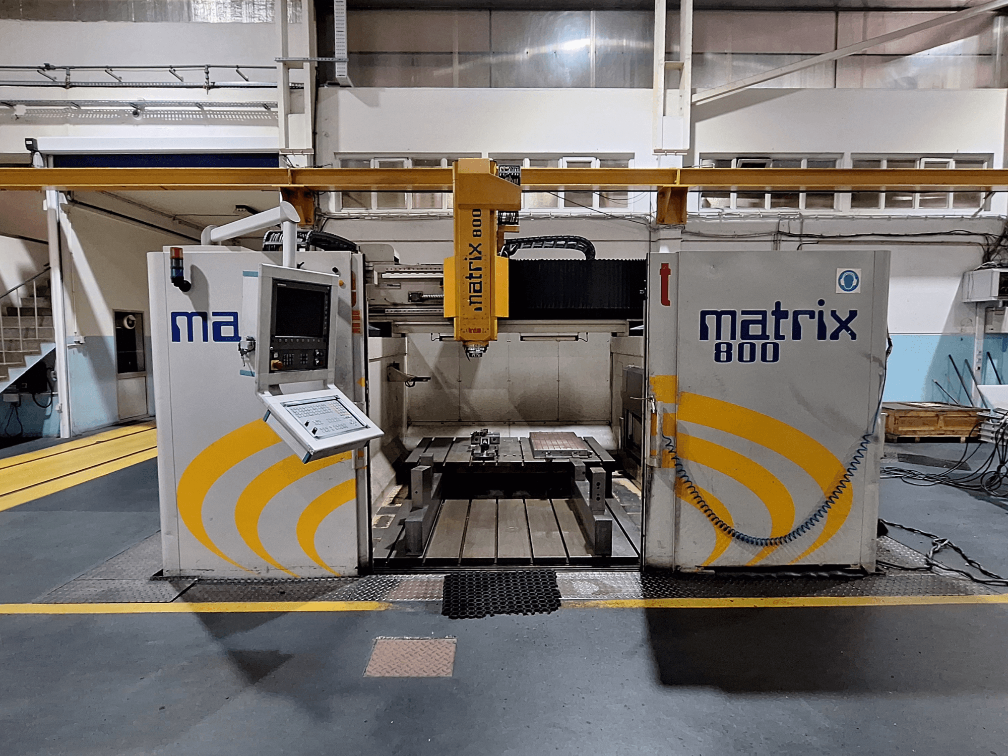 Portalinės frezavimo staklės "Breton Matrix WM 800 K25" dirbtuvėse, iš priekio matomas valdymo skydelis ir stalas.