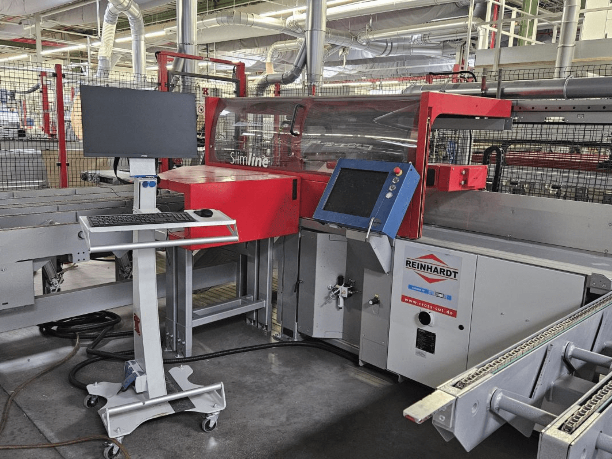 Kryžminio pjovimo pjūklo "Paul Reinhardt SlimLine 110" optimizavimas, vaizdas iš priekio su valdymo skydeliu ir monitoriumi, skirtu darbui nustatyti.