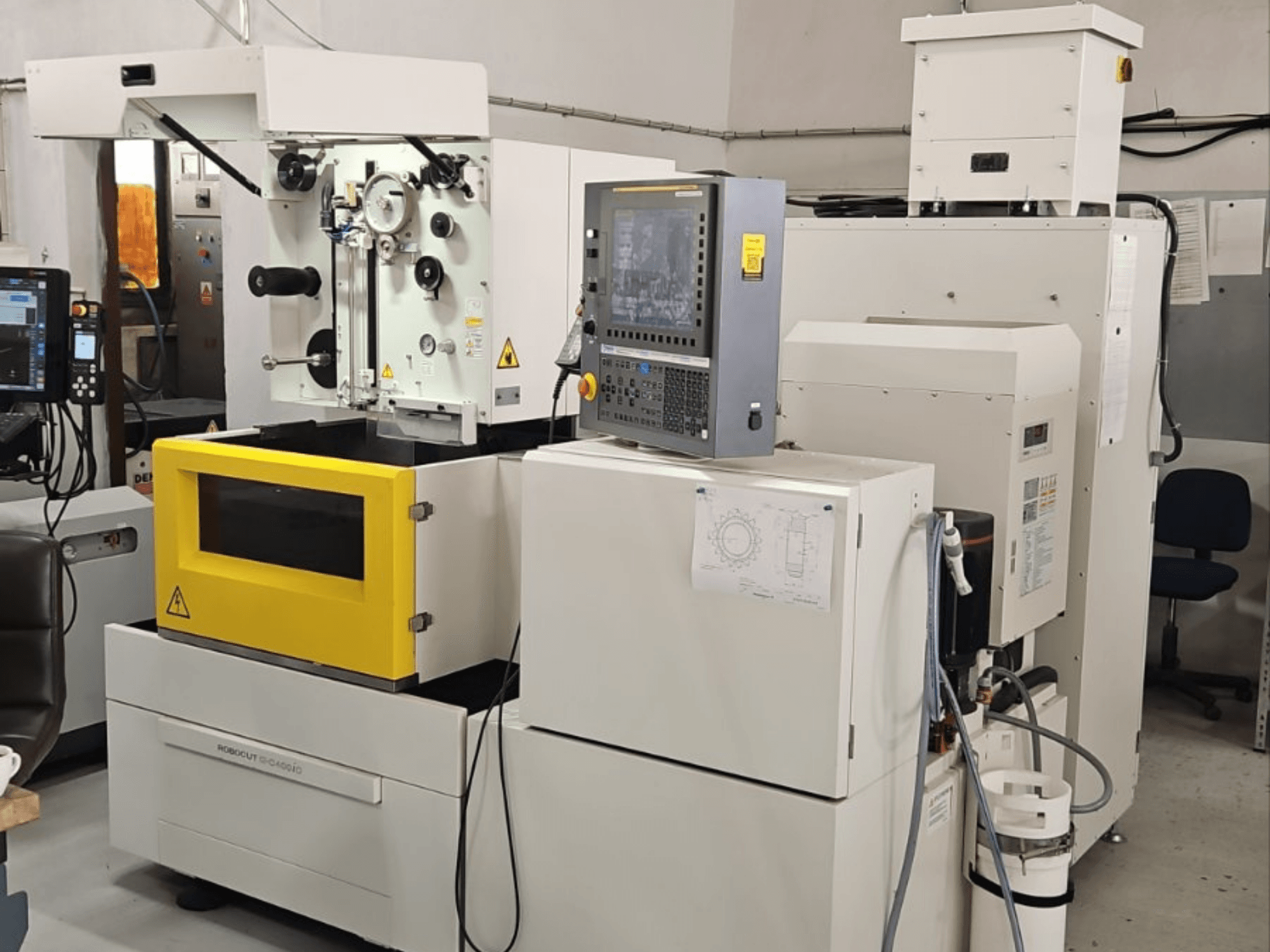 „FANUC Robocut alpha C400iC“ vielinės elektros erozijos staklės, vaizdas iš priekio, kuriame matomas valdymo skydas ir geltona darbo kamera.