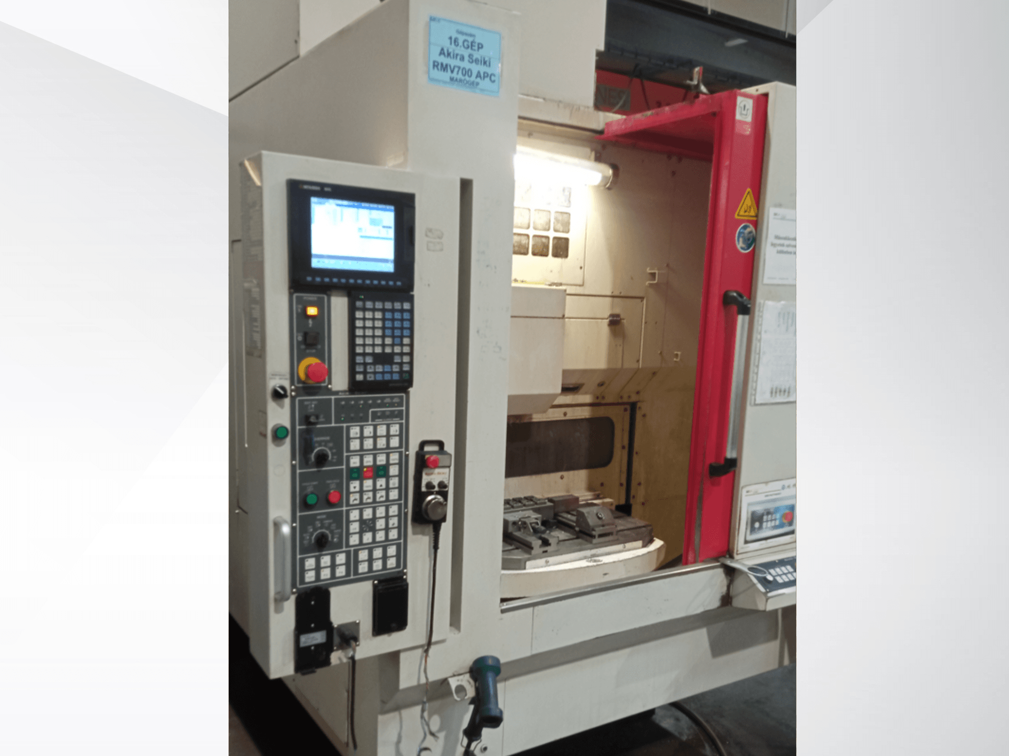 Akira Seiki RMV 700 APC vertikalaus apdirbimo centro priekinis vaizdas, skaitmeninis valdymo skydelis ir darbo zona su įrankiais.