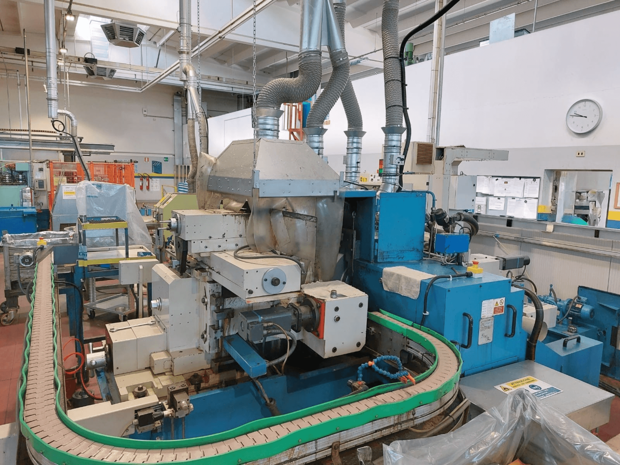 GHIRINGHELLI M300SP610 CNC3A becentrinio šlifavimo staklės, priekinis vaizdas, kuriame matyti sudėtingos mašinų ir konvejerių detalės.