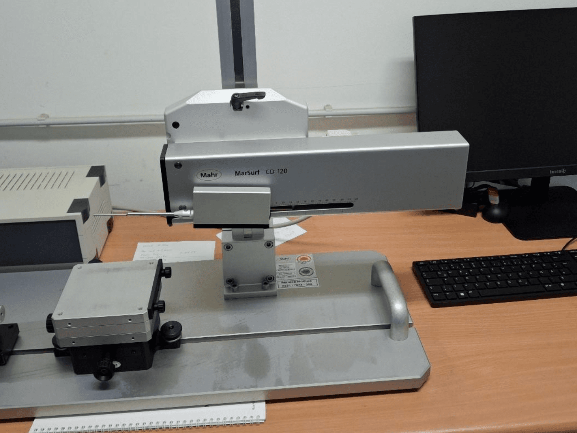 "Mahr MARSURF CD 120 CMM", žiūrint iš priekio, matoma matavimo galvutė, valdymo skydelis ir sumontuotas matavimo stalas.