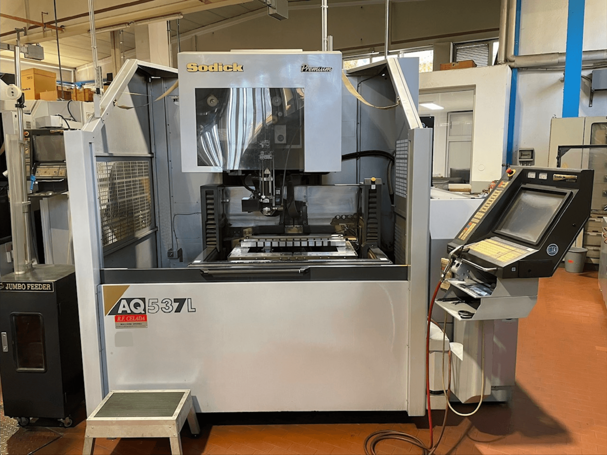 Sodick AQ537L vielos EDM staklių priekinis vaizdas, kuriame matomas valdymo skydelis ir apdirbimo zona su matomais komponentais.