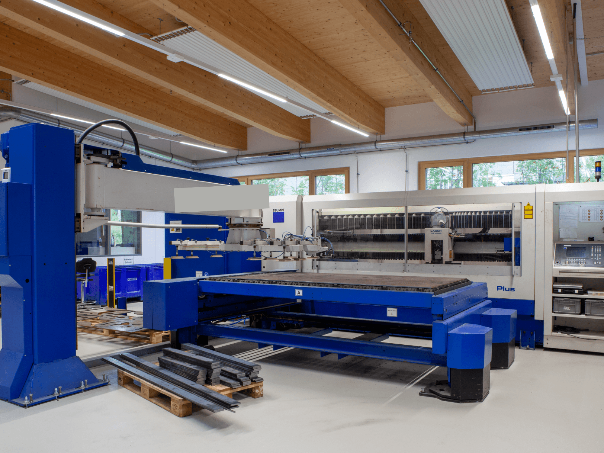 „TRUMPF TRUMATIC L 2530 Plus“ CO₂ lazerio pjovimo staklės dirbtuvėse, pasižyminčios dideliu pjovimo stalu ir pramoniniu dizainu.