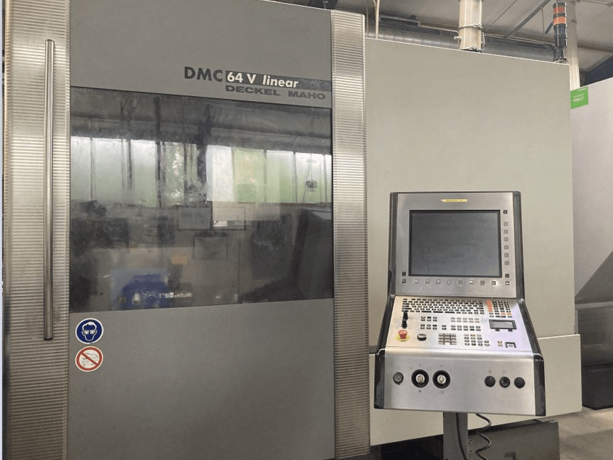 DMG DECKEL MAHO DMC 64V linijinis vertikalusis apdirbimo centras, priekinis vaizdas, kuriame matomas valdymo skydelis ir ekranas.