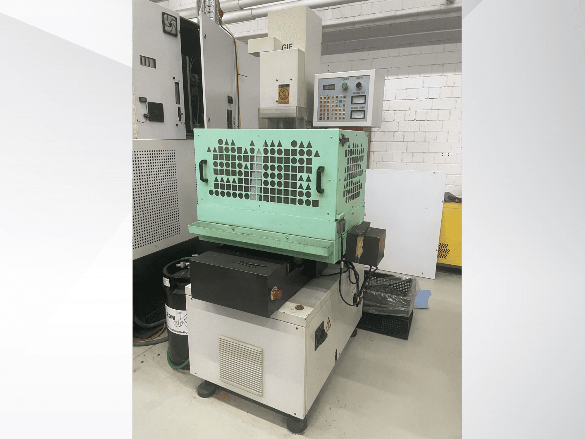 AGIE Drill, metalo gręžimo staklės, iš priekio matomi valdikliai, žalias korpusas ir kompaktiška konstrukcija. Idealiai tinka tiksliems darbams.