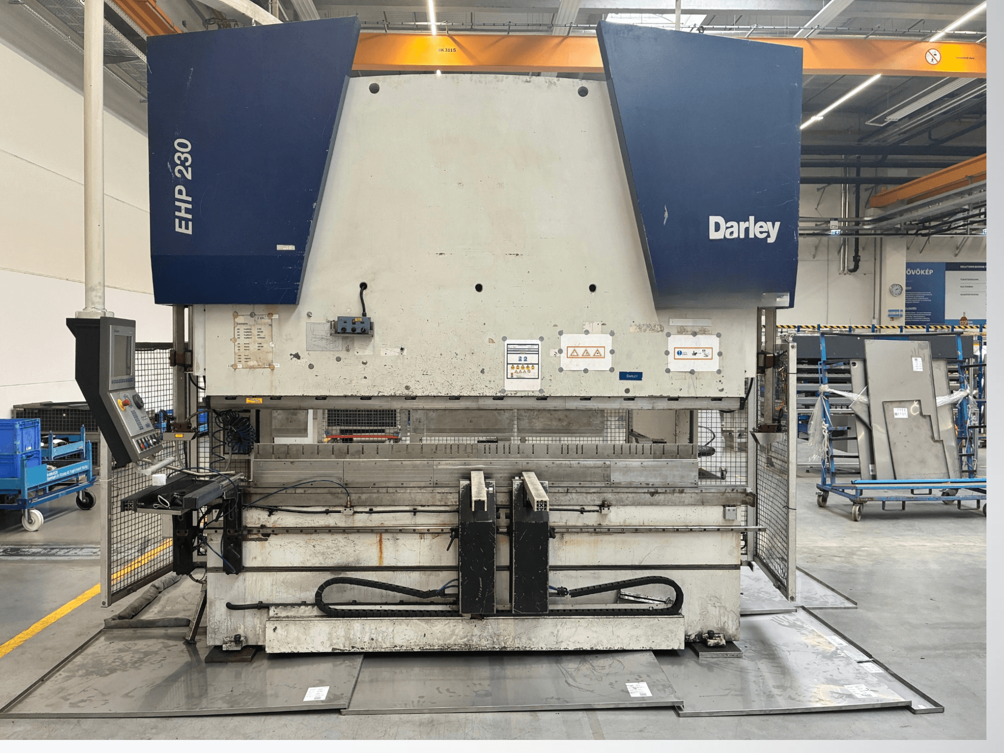 Hidraulinis presas Darley EHP-LS 230.31/25, vaizdas iš priekio, šalia - valdymo skydelis ir metalo lakštai. Idealiai tinka pramoniniam naudojimui.
