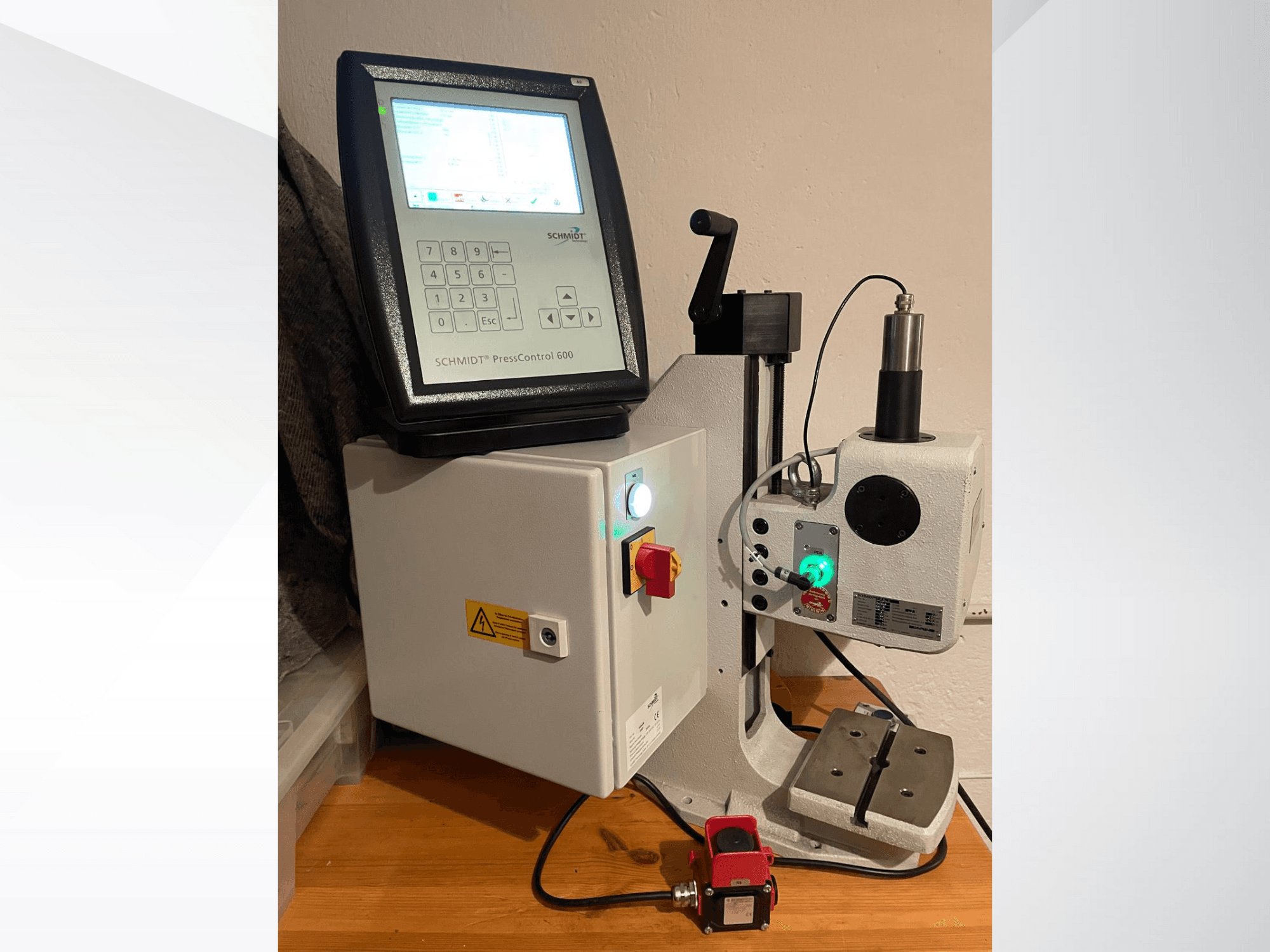 SCHMIDT® PressControl 600, vaizdas iš priekio, kuriame matomas valdymo skydelis, maitinimo mygtukas ir hidraulinis presas su saugos funkcijomis.