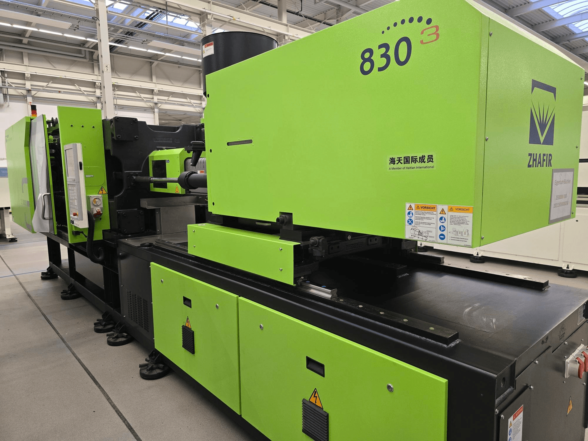 ZHAFIR ZERES III 3000/830/B5 elektrinė įpurškimo mašina, vaizdas iš šono, matomas ryškiai žalias korpusas ir valdymo skydelis.