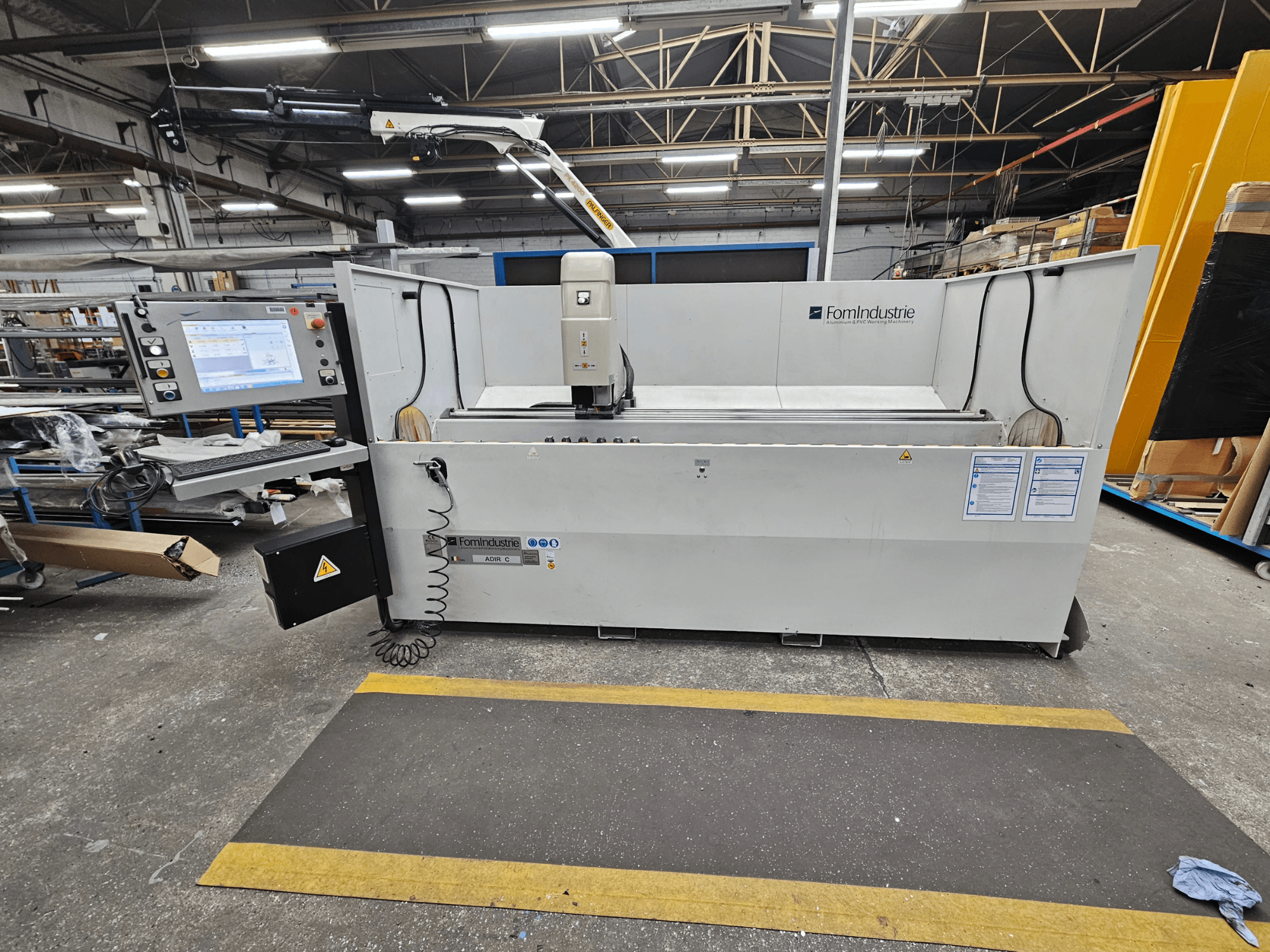 "FomIndustrie ADIR C" vertikalusis apdirbimo centras dirbtuvėse, priekinis vaizdas, kuriame matomas valdymo skydelis ir staklių detalės.