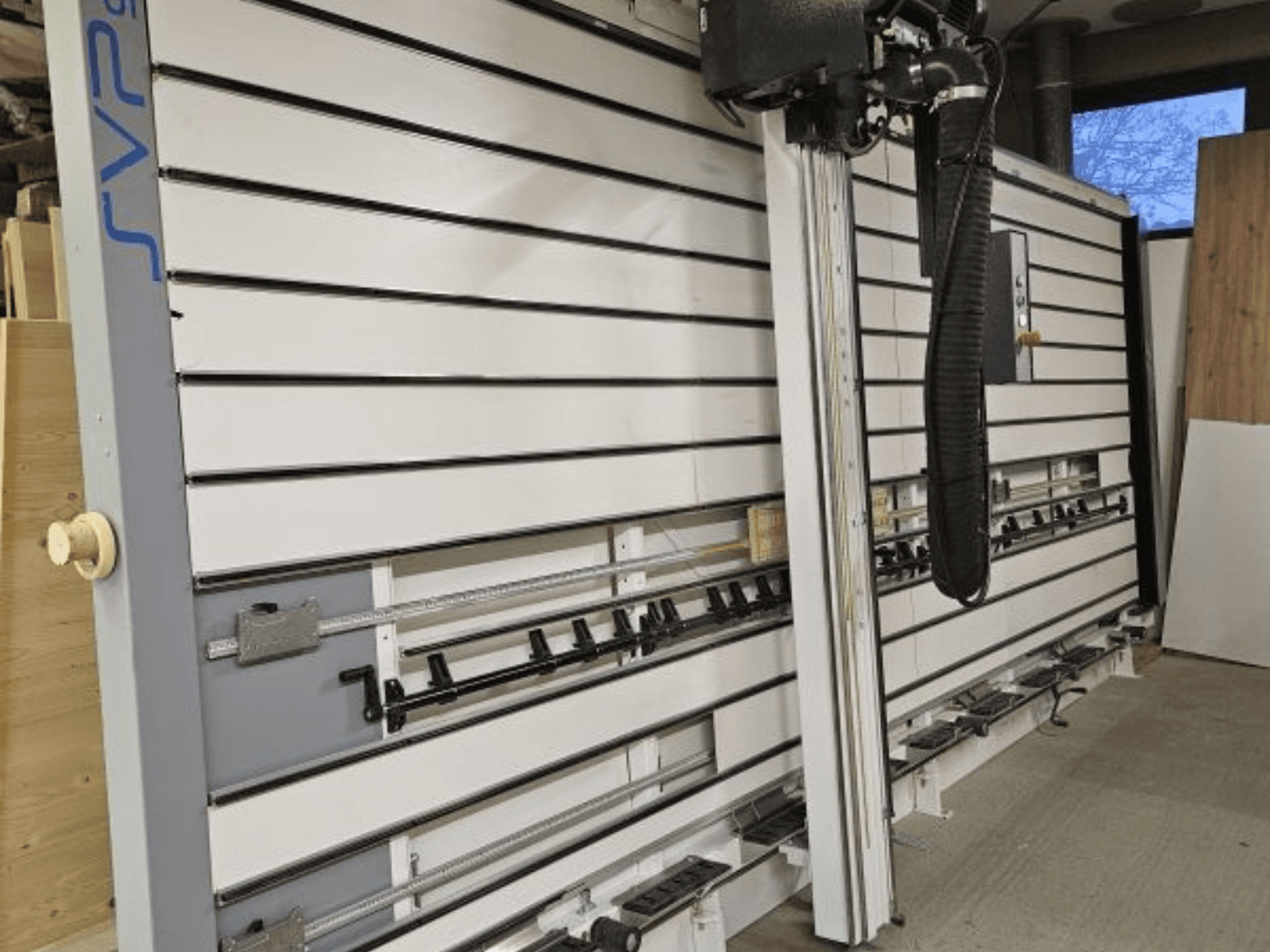 SVP stumdomas plokščių pjūklas dirbtuvėse, vaizdas iš priekio, su reguliuojamais bėgiais ir viršutine dulkių ištraukimo sistema.