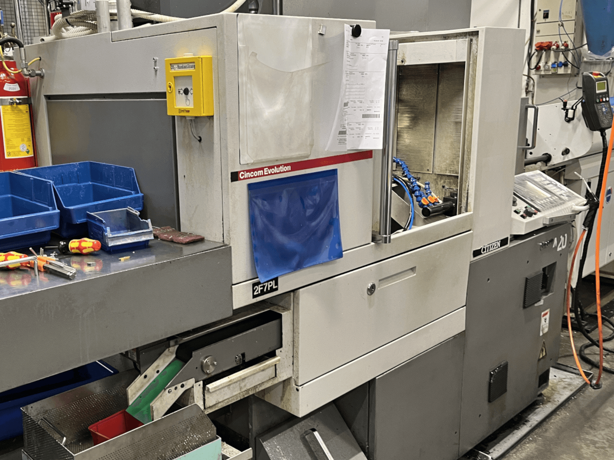 "Cincom Evolution 2F7PL" apdirbimo centras, vaizdas iš priekio; yra valdikliai, įrankių dėžės ir detalus valdymo skydelis.