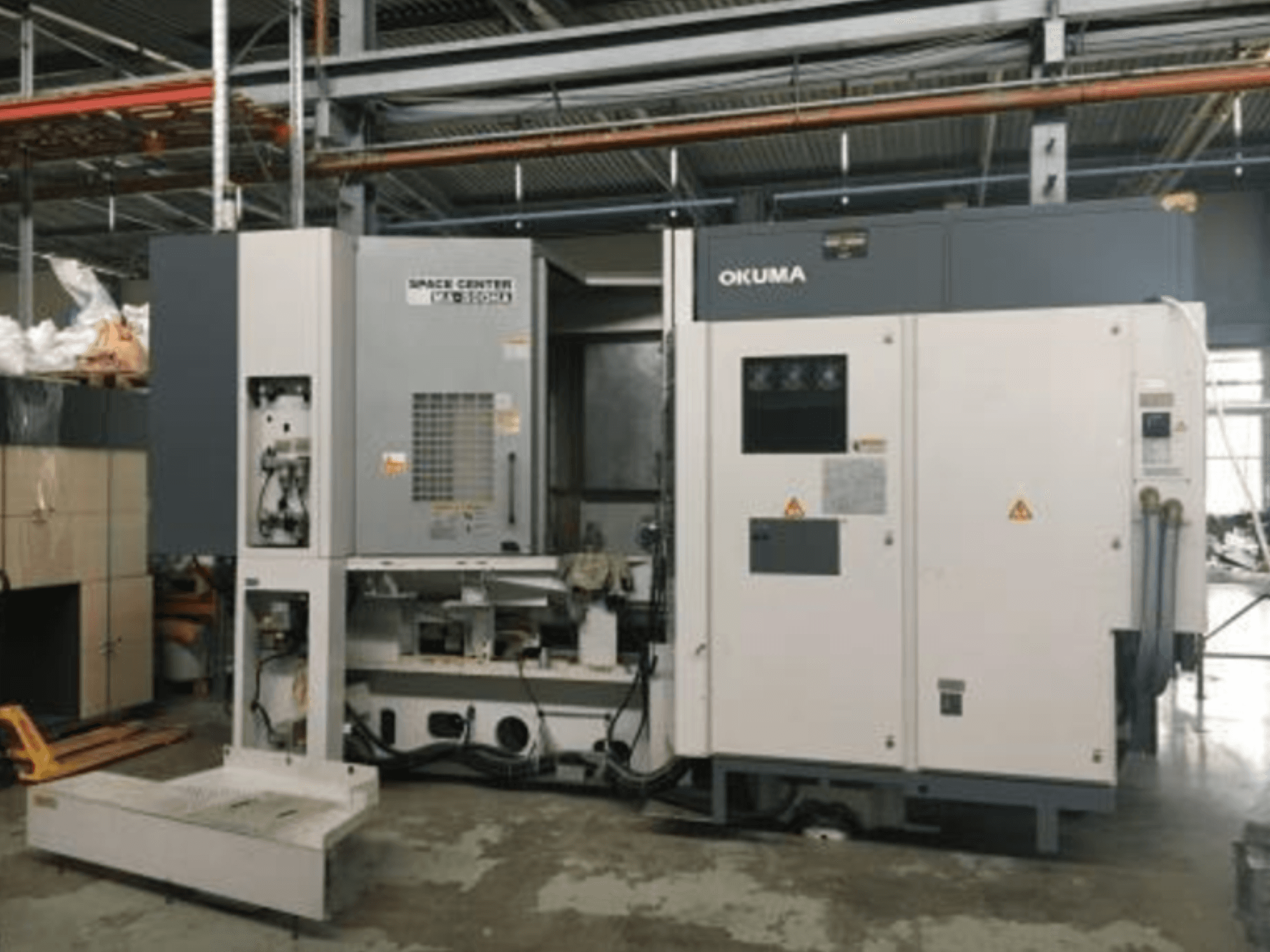 „Okuma SPACE CENTER MA-500HA“ horizontalaus apdirbimo centro vaizdas iš priekio, kuriame matomas valdymo pultas ir mechaniniai komponentai.
