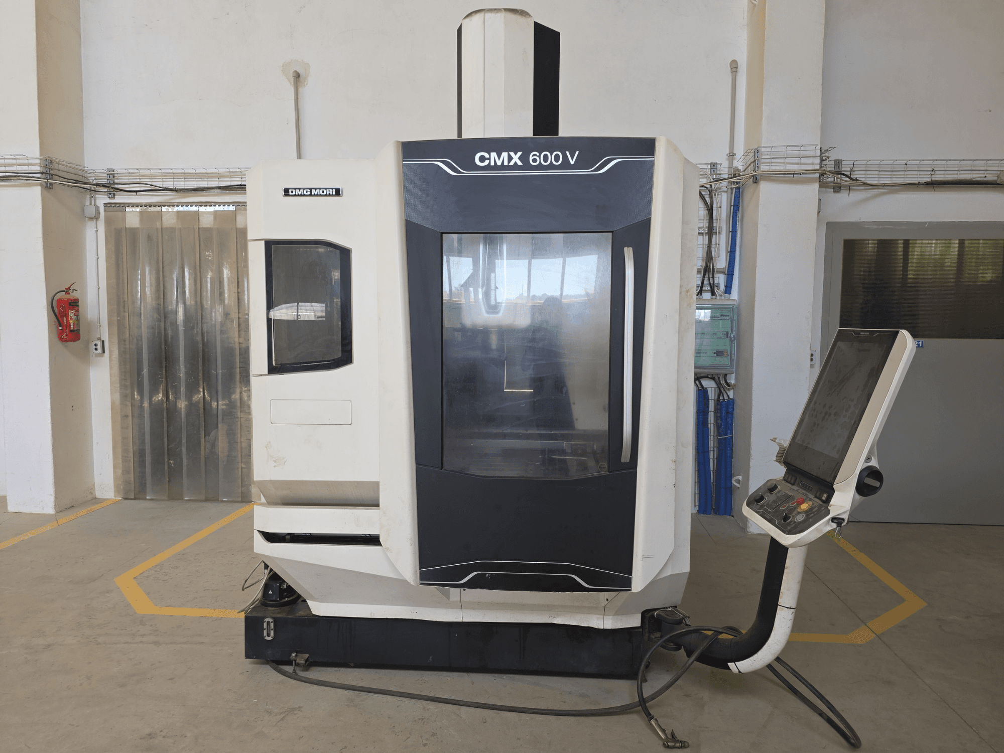 DMG MORI CMX 600 V vertikalusis apdirbimo centras, vaizdas iš priekio, valdymo skydelis ir didelis skaidrus langas.