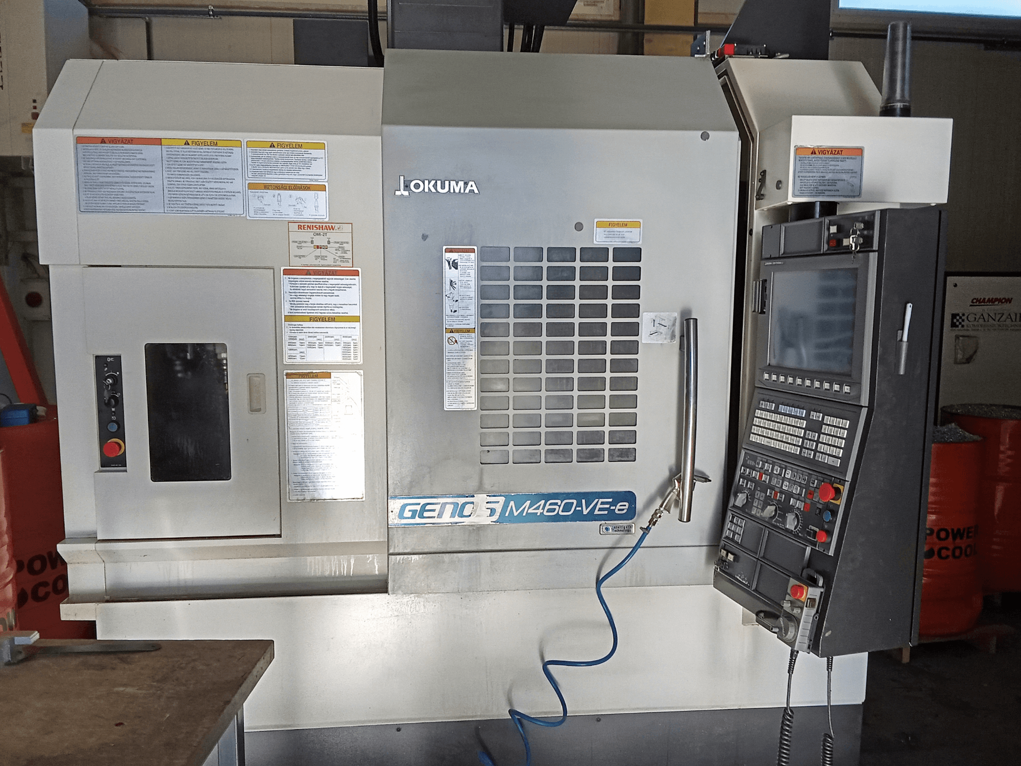 Vertikalaus apdirbimo centro "Okuma M460R-VE" priekinis vaizdas, kuriame matomas valdymo skydelis ir darbinės sąsajos detalės.