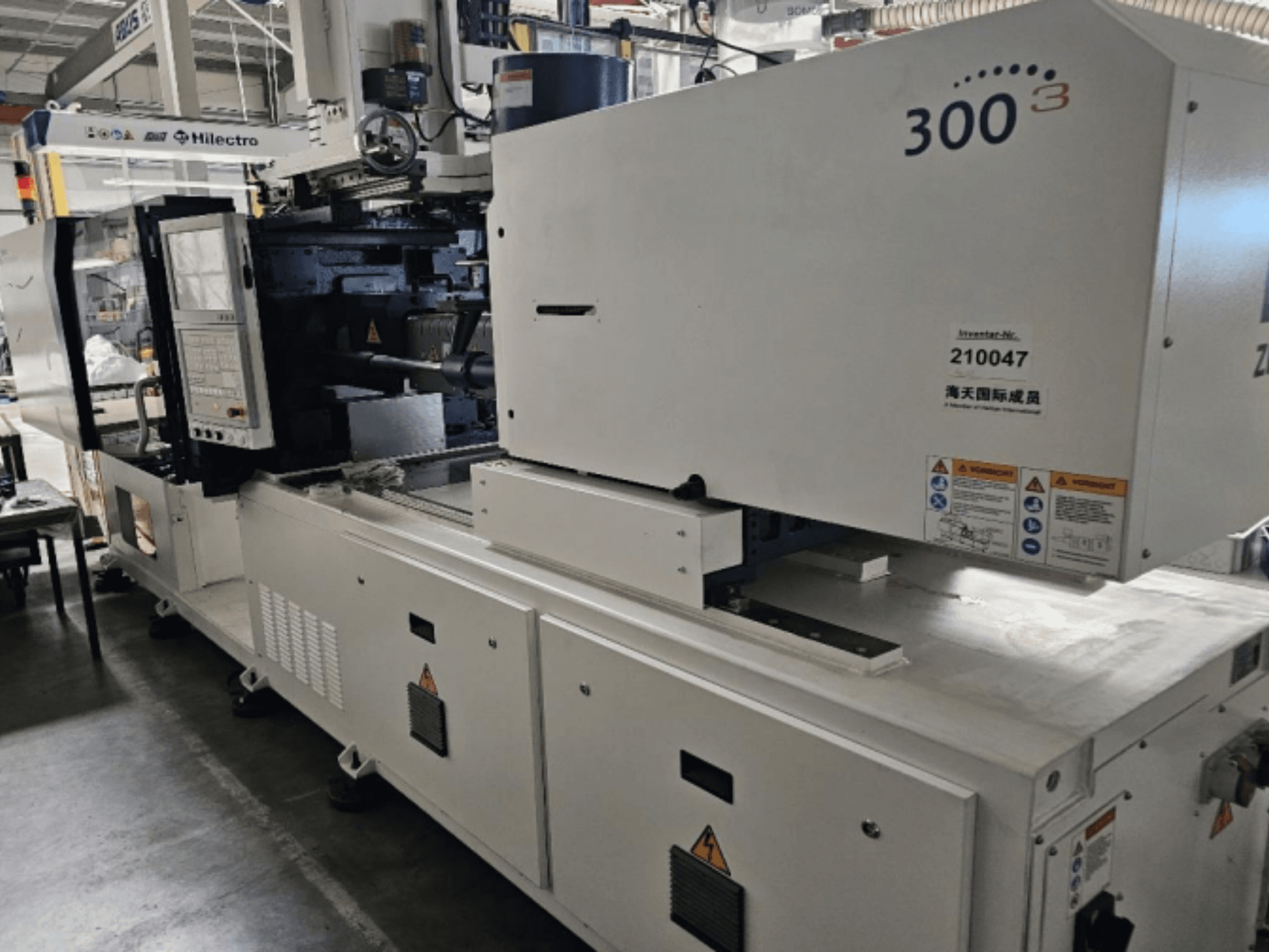 Zhenjing prekės ženklo 300 modelio liejimo mašina, vaizdas iš priekio, matomas valdymo skydelis ir įspėjamosios saugos etiketės.