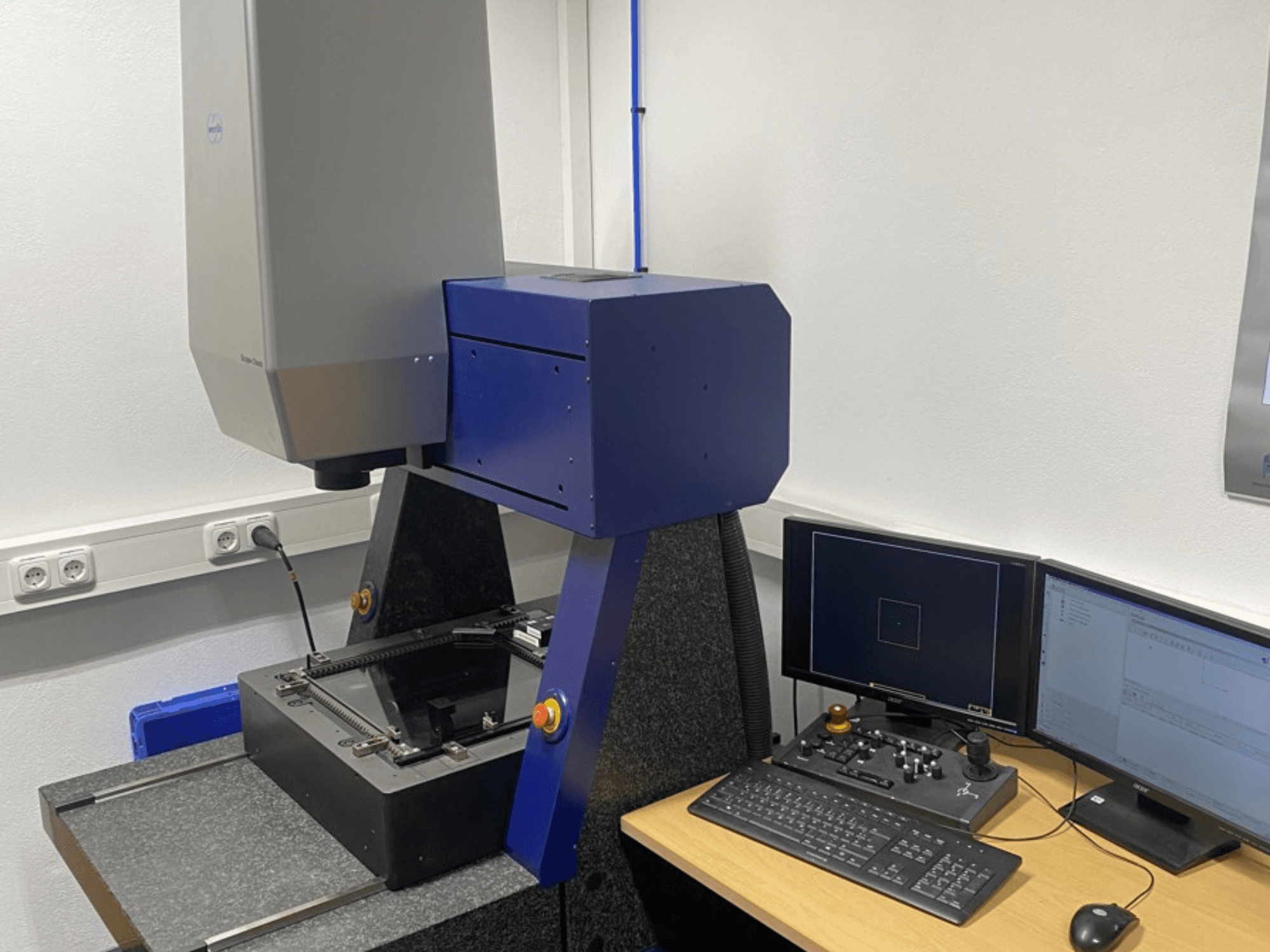 Werth Scope-Check 400 KMM laboratorijoje, matoma matavimo galvutė ir valdymo skydelis su ekranais ir klaviatūra.