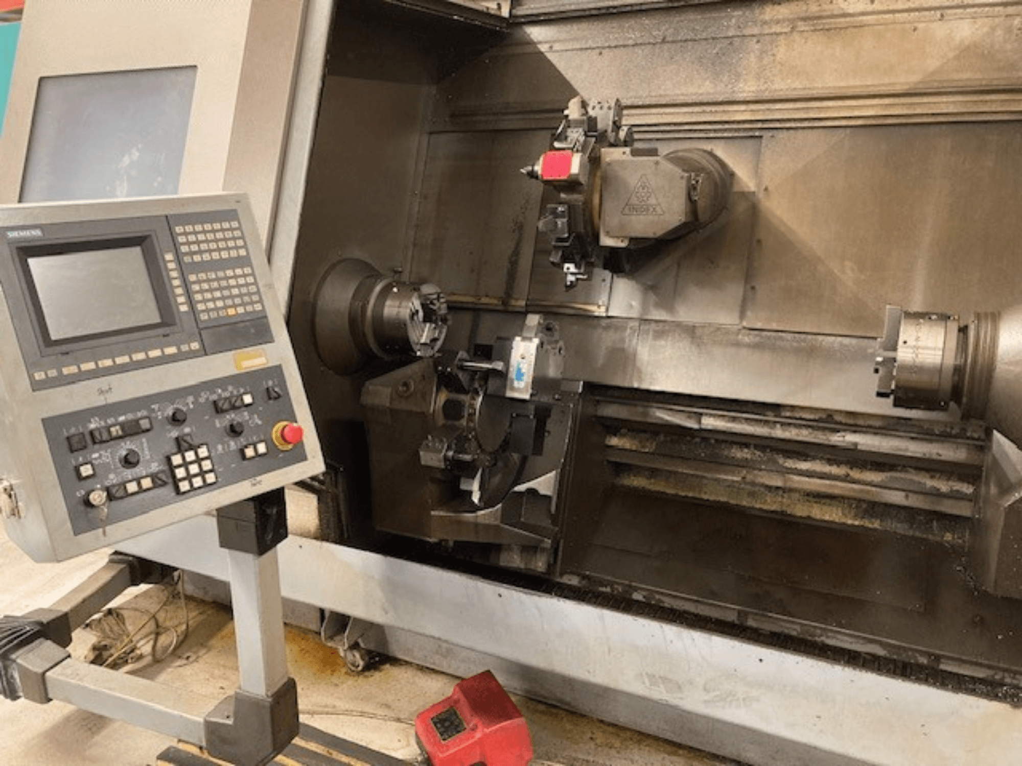 Horizontalios tekinimo staklės Index G300 L YB su valdymo skydeliu, matomu griebtuvu ir darbo zona, vaizdas iš priekio.