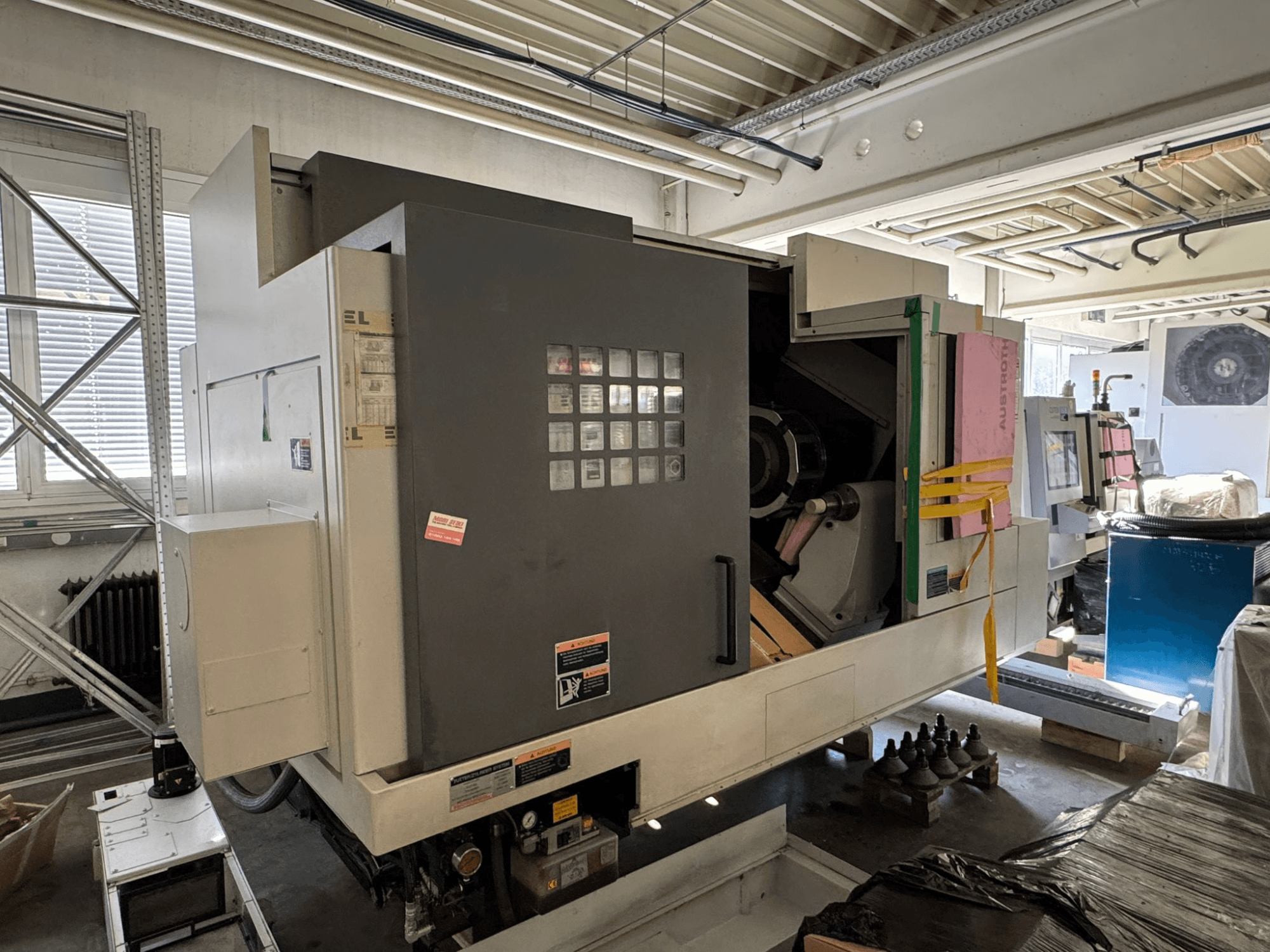 MORI SEIKI NL 3000 MC/700 horizontalusis tekinimo staklės, vaizdas iš priekio su valdymo pultu, daiktų laikymo vieta ir apsaugine danga.