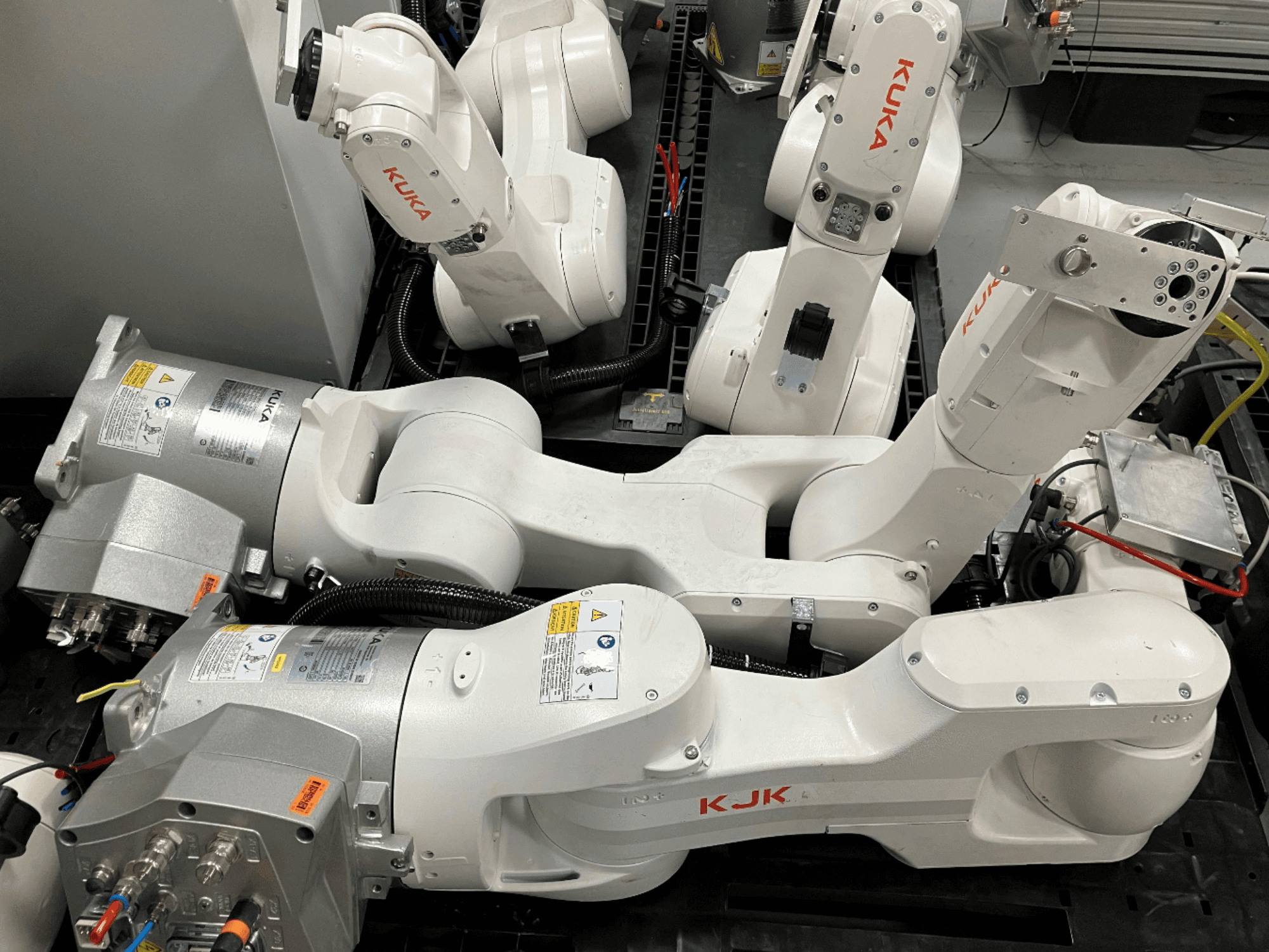 KUKA KR 10 R900 CR roboto rankos šoninis vaizdas, kuriame matyti sąnario konstrukcija, varikliai ir laidų detalės.