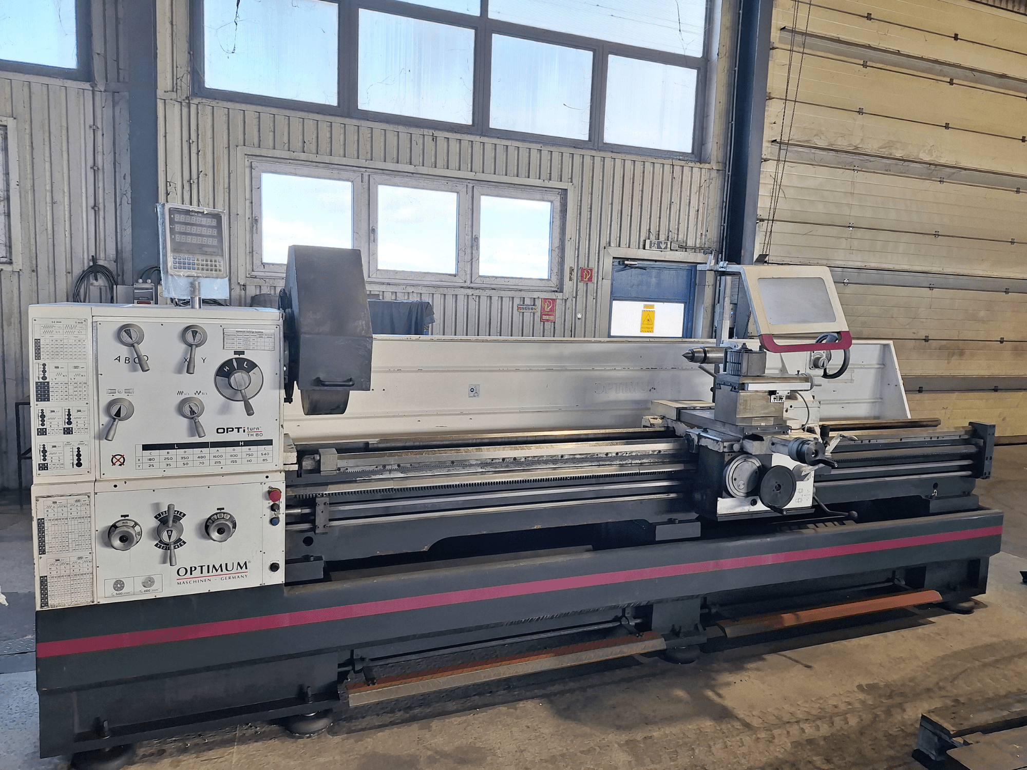Horizontalios tekinimo staklės "Optimum OptiTurn TH 8030D" su valdymo pultu, įrankių laikikliu ir tvirtu pagrindu.