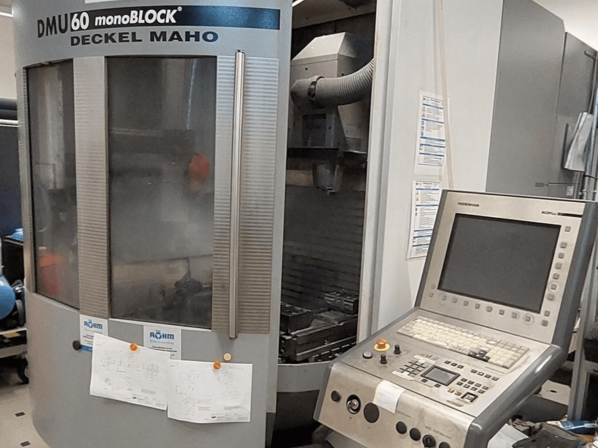 "Deckel Maho" DMU 60 monoBLOCK, CNC frezavimo staklių vaizdas iš priekio su valdymo skydeliu ir pridėtais techniniais brėžiniais.