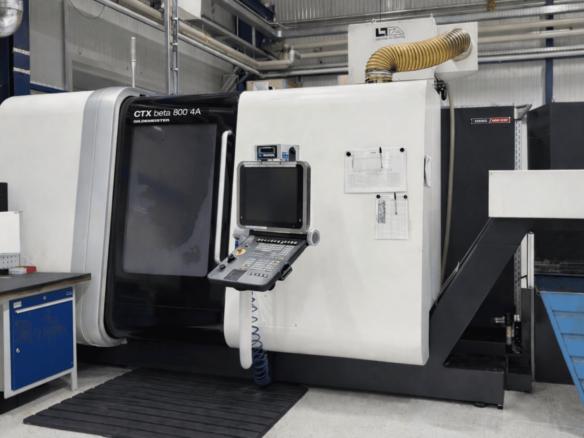 Daugiaspindulinis tekinimo staklės „DMG CTX beta 800 4A“, vaizdas iš priekio, kuriame matomas valdymo pultas ir eksploatacijos dokumentai.