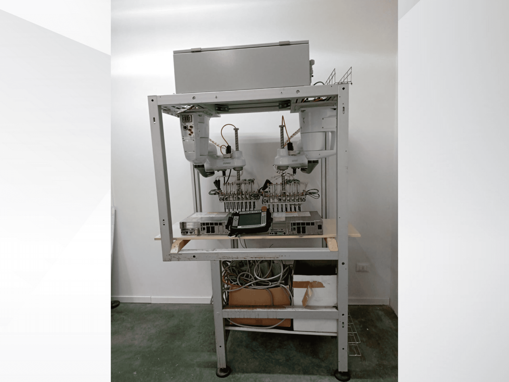 Automatizuota robotizuota darbo vieta su dviem rankomis, vaizduokliu ir elektronika ant metalinio rėmo, vaizdas iš priekio, pažangi technologinė sąranka.