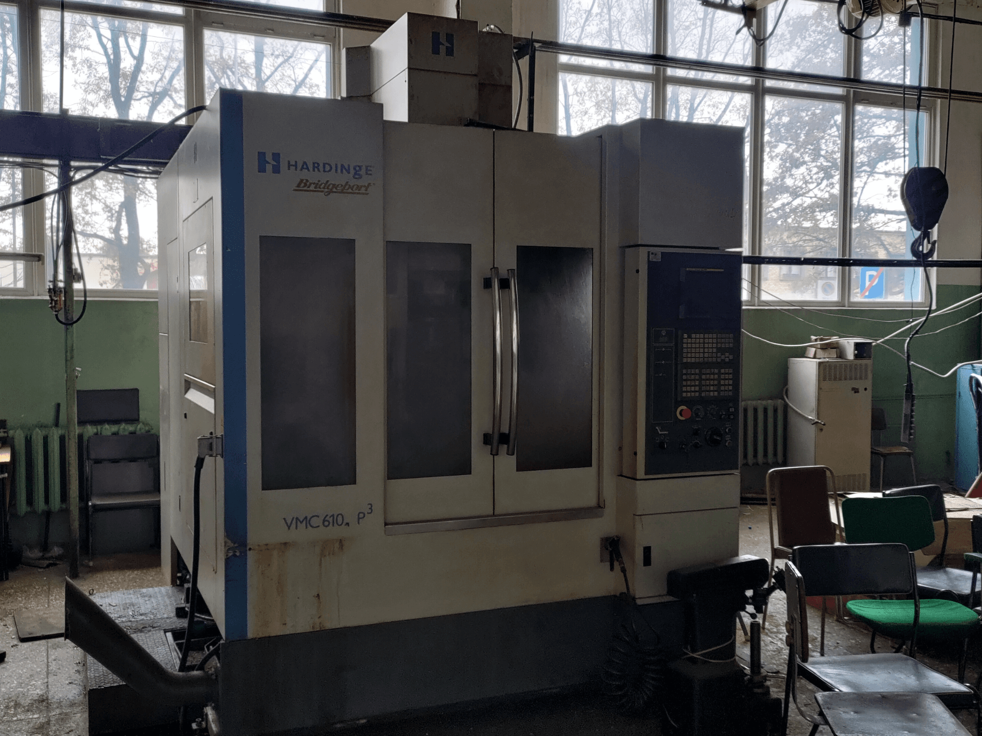 „Bridgeport VMC-610 XP3“ vertikalusis apdirbimo centras, vaizdas iš priekio, kuriame matomas valdymo pultas ir didelės stiklinės durys.