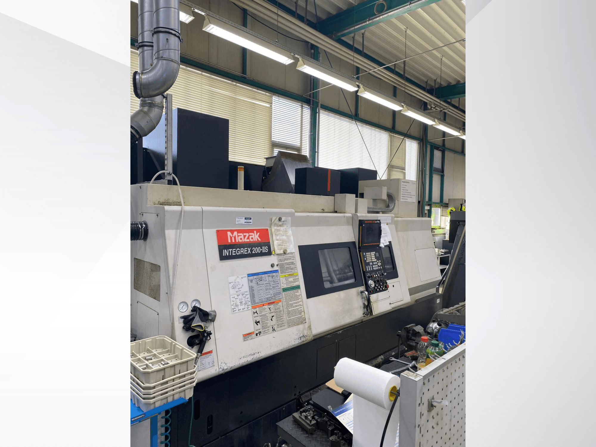 „Mazak INTEGREX 200 III S“ tekinimo ir frezavimo centras, vaizdas iš šono, kuriame matomas valdymo pultas, matuokliai ir darbo vietos įrankiai.