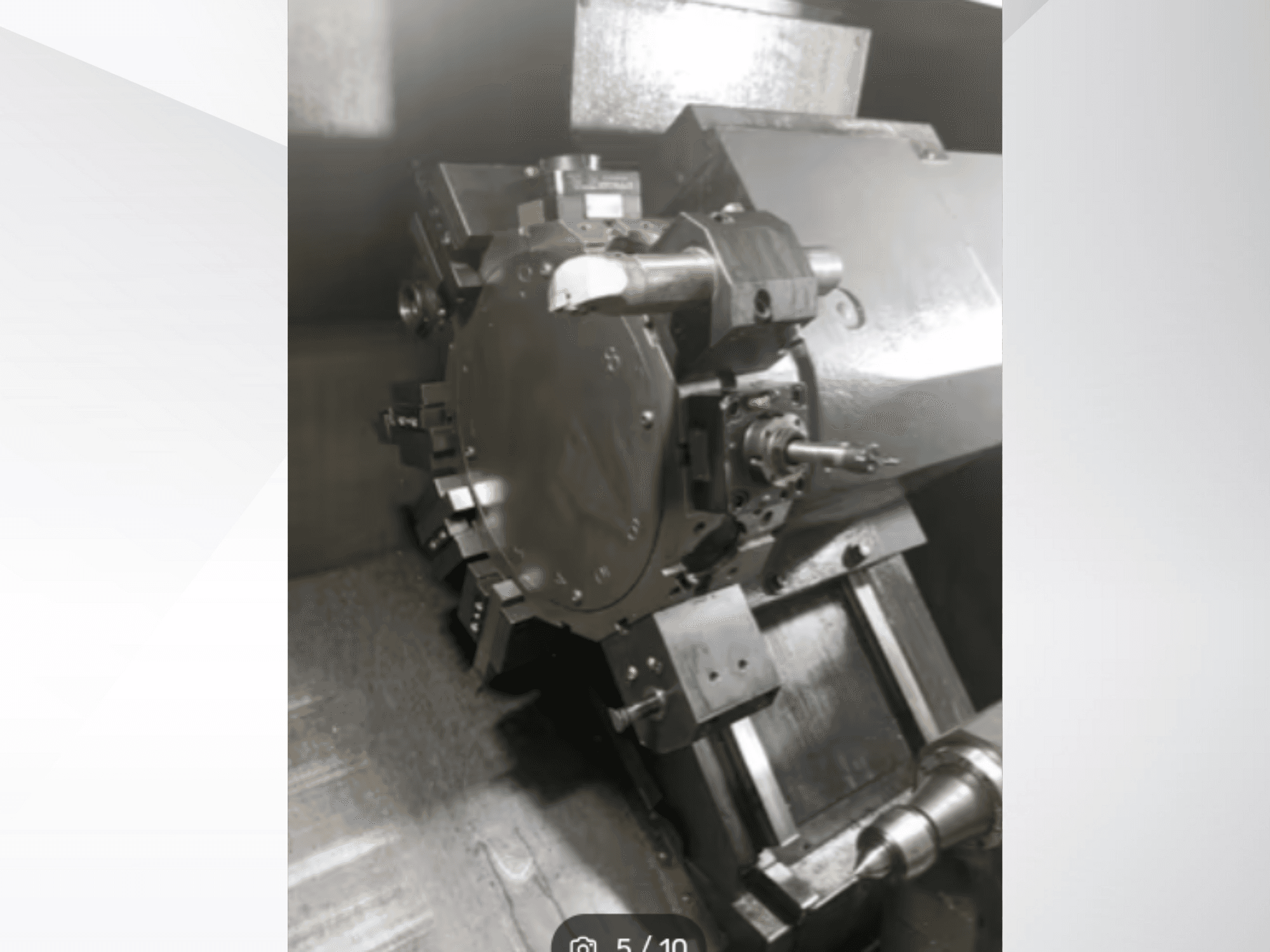 Tiksliosios mašinos detalės stambiu planu, kuriame matyti krumpliaračiai ir metaliniai komponentai, žiūrint iš kampinės perspektyvos. Prekės ženklo nematyti.