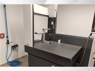 MSR matavimo prietaisas laboratorijoje, iš priekio matomas granito stalas, kalibravimo sfera ir prijungtos priemonės.